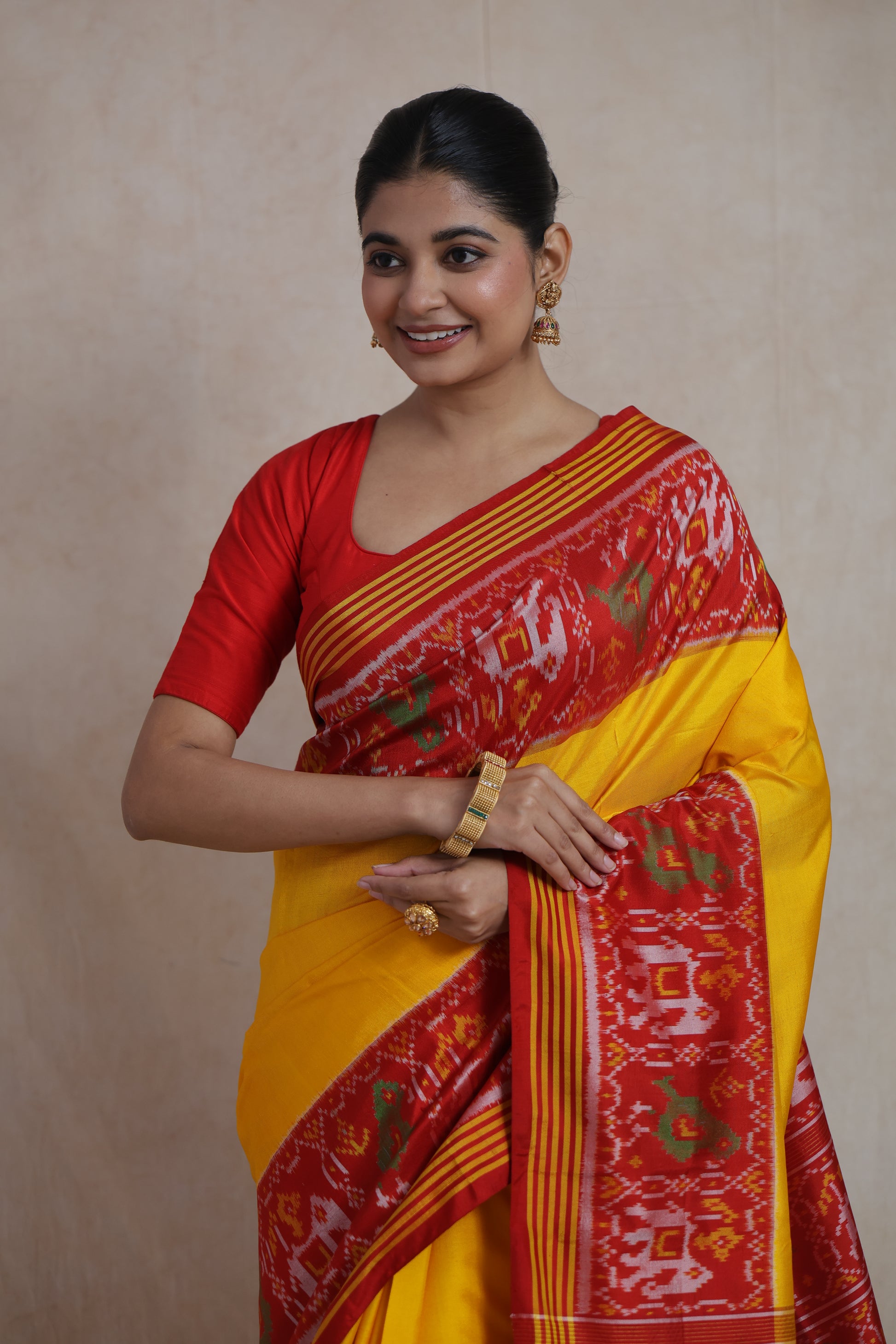 Front drape detail of yellow Patola handloom silk saree showcasing intricate woven ikat motifs