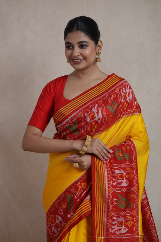 Front drape detail of yellow Patola handloom silk saree showcasing intricate woven ikat motifs