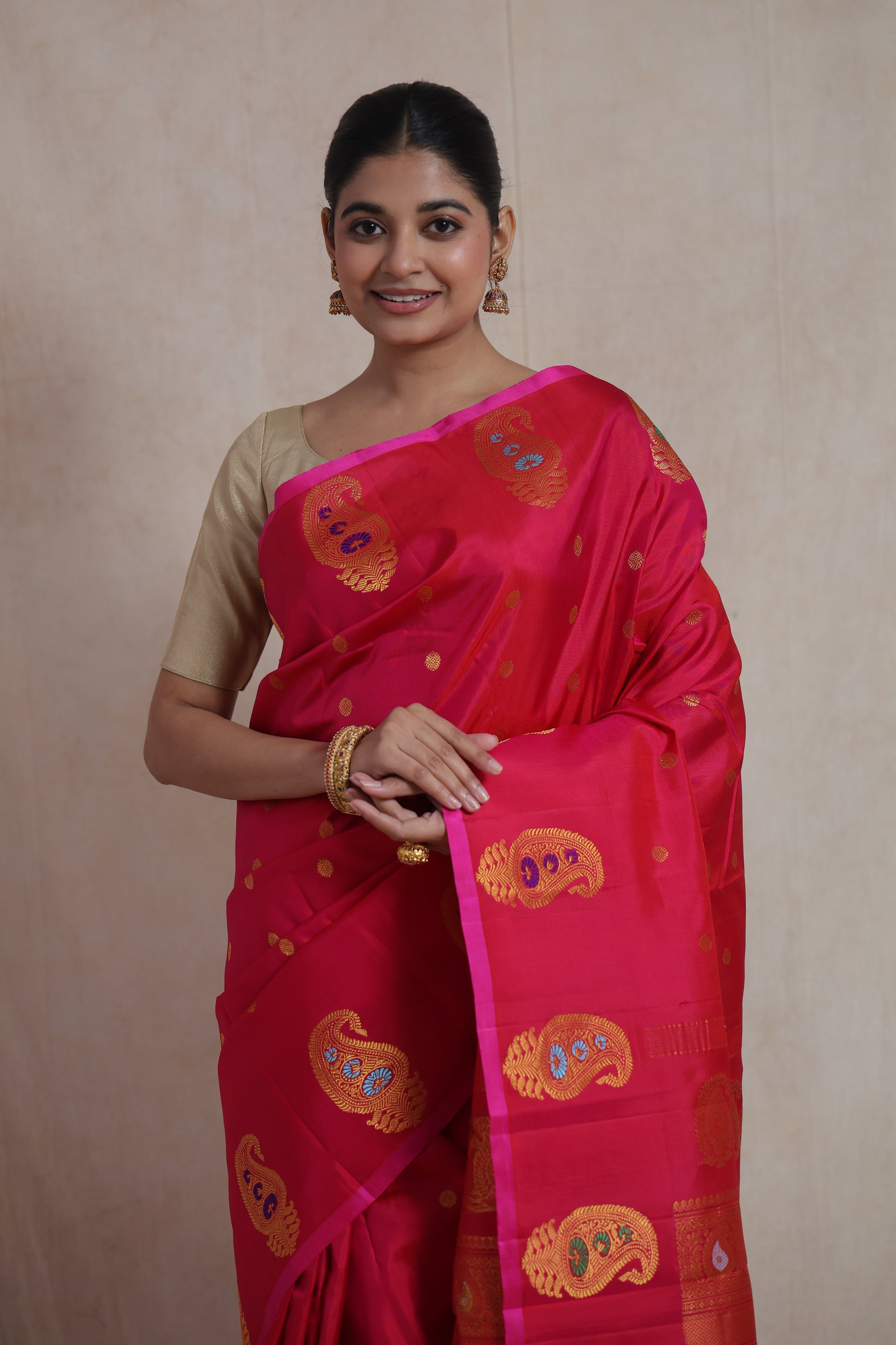 Close-up of the rani pink Gadwal silk saree highlighting woven paisley motifs and delicate buttas.