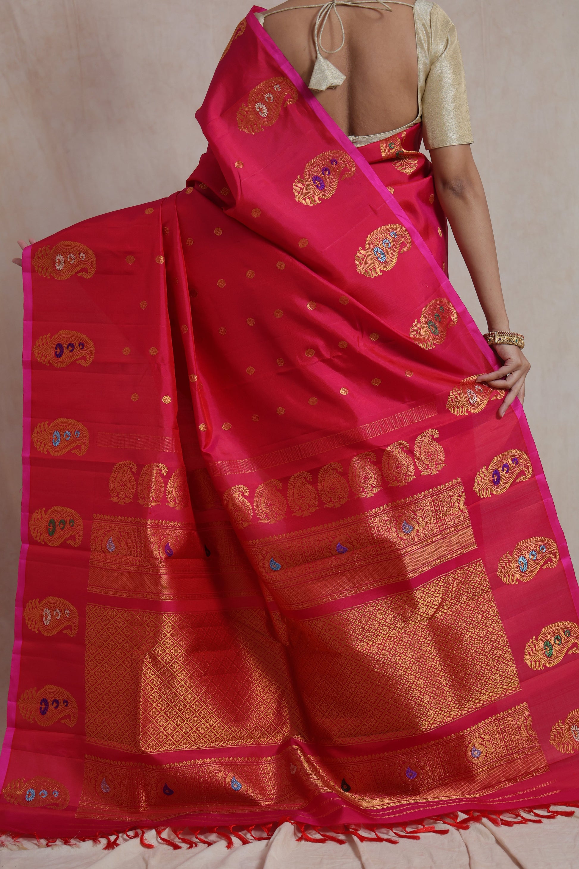Back view displaying the luxurious woven pallu and traditional border of the rani pink Gadwal silk saree.