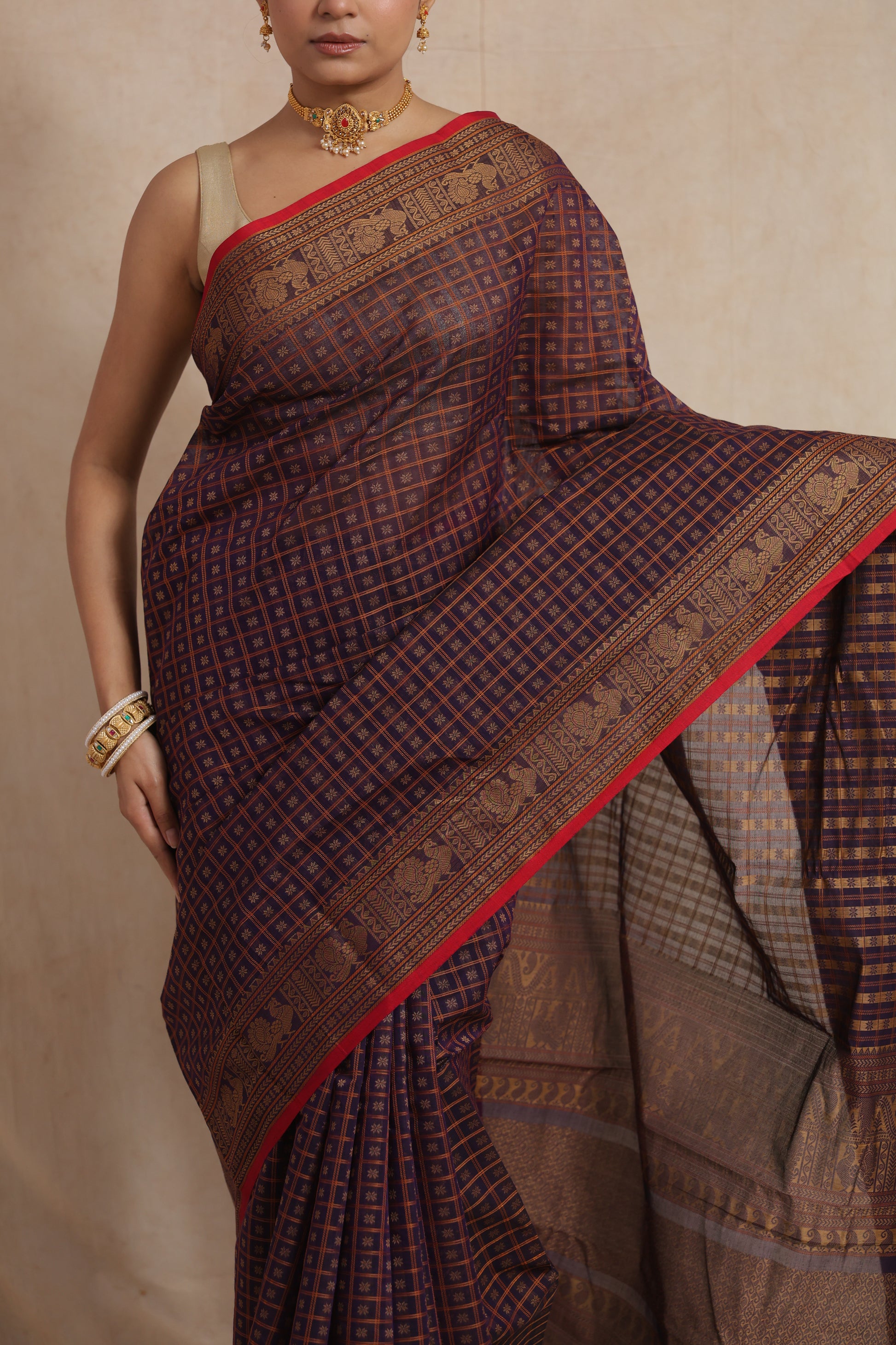 Close-up of handloom cotton saree with geometric checks and contrast red border