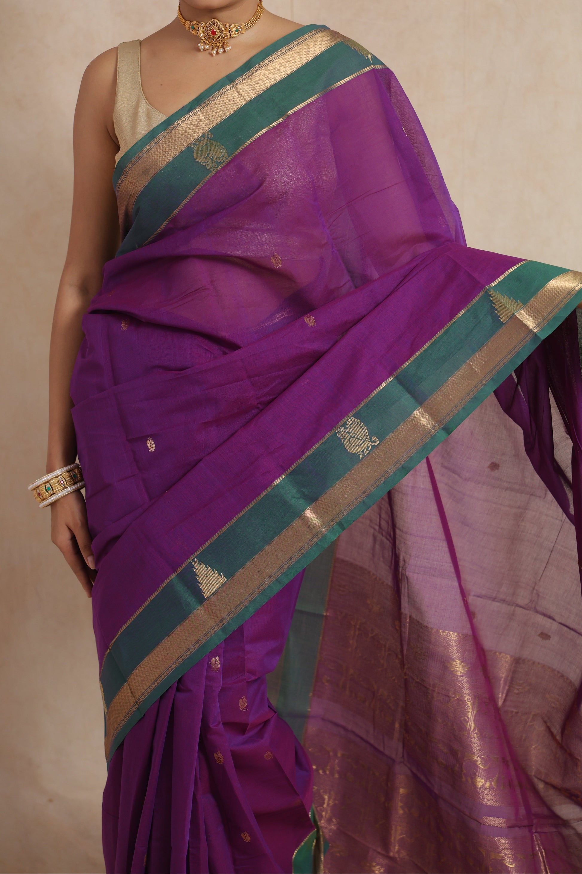 Detailed view of royal purple cotton saree showcasing woven buttas and traditional border patterns