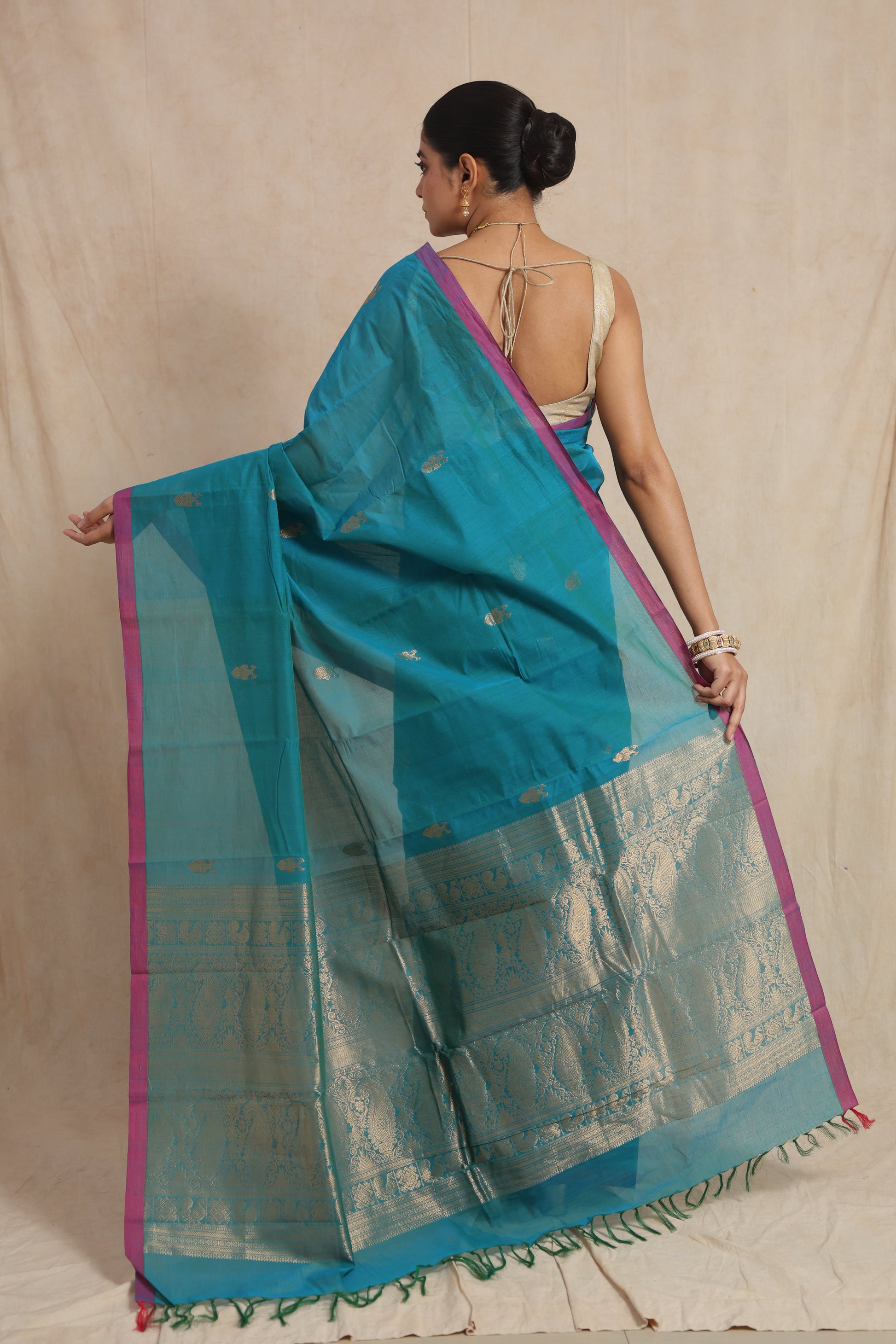 Back view of turquoise blue handloom cotton saree showcasing intricately woven traditional pallu