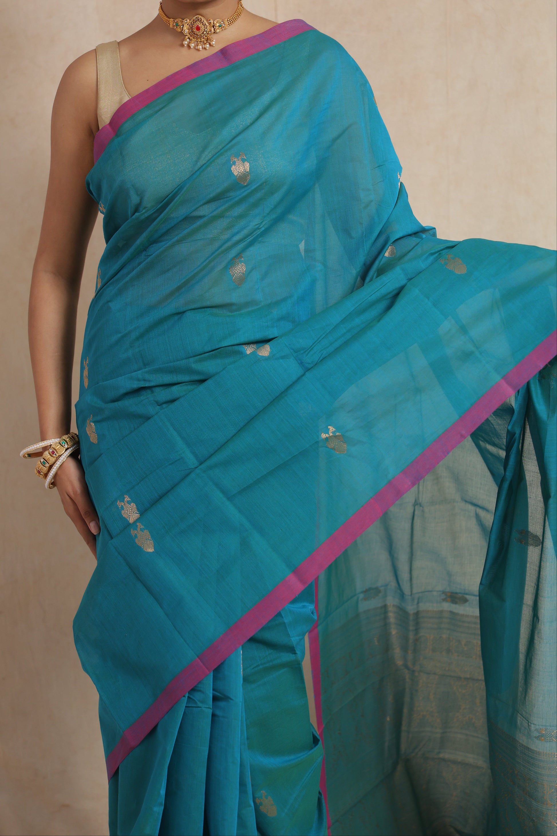 Detailed view of turquoise blue Kanchipuram cotton saree with woven motifs and contrast border
