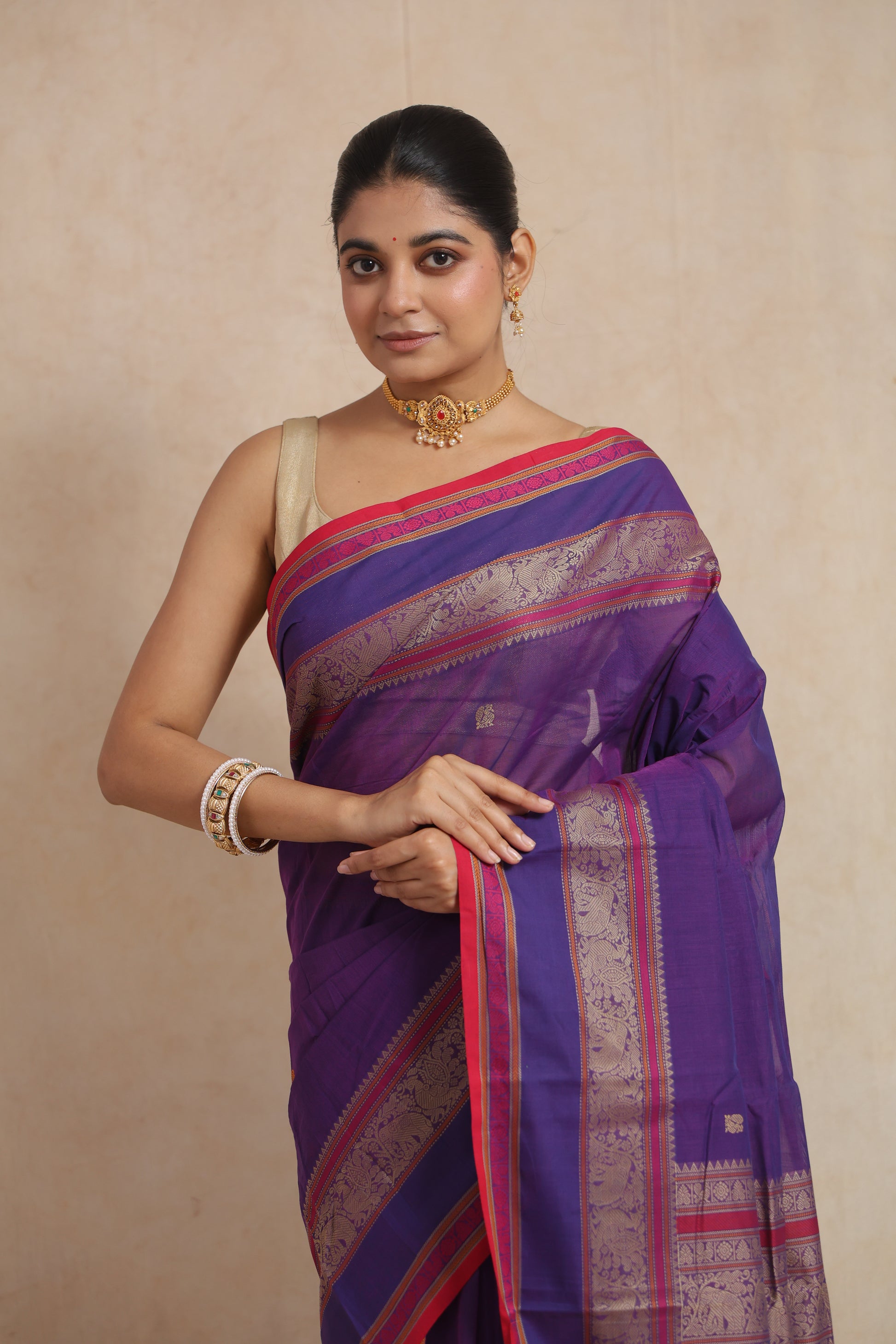 Close-up of royal purple cotton saree featuring intricate woven border and elegant drape
