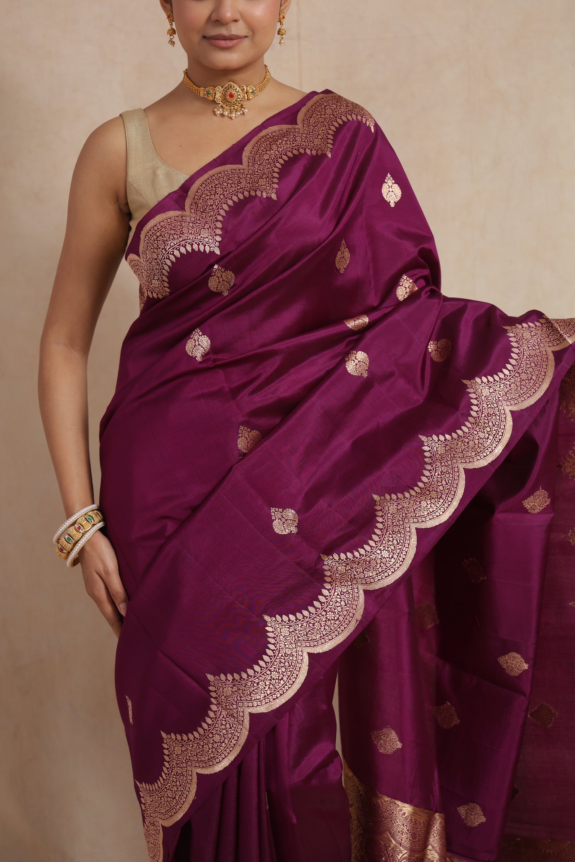 Close-up of royal magenta Banarasi art silk saree showcasing intricate scalloped woven border and buttas
