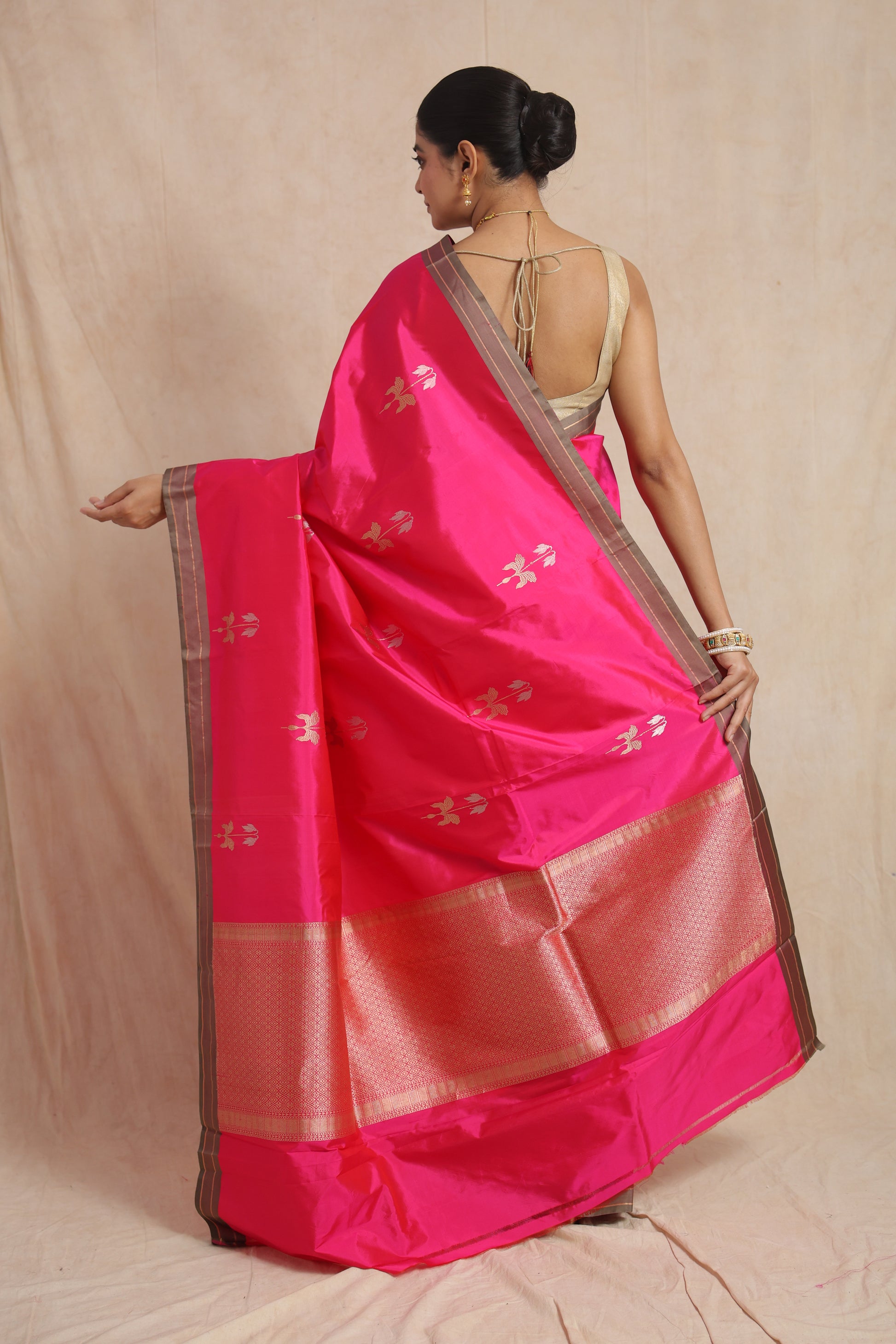 Back view displaying the richly woven pallu and elegant contrast border of the hot pink Banarasi silk saree.