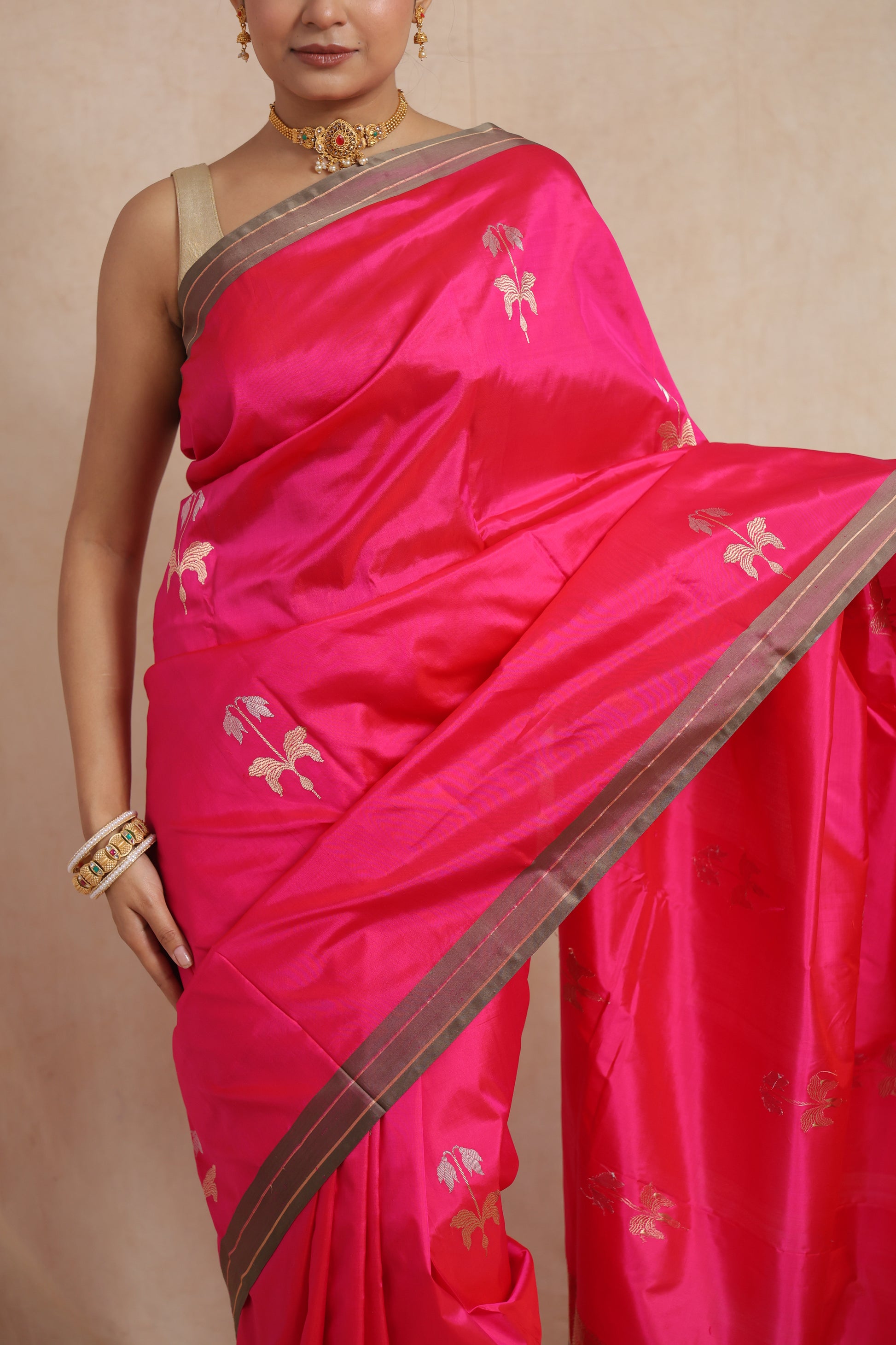 Detailed drape view of the hot pink Banarasi silk saree highlighting floral woven motifs and fine craftsmanship.