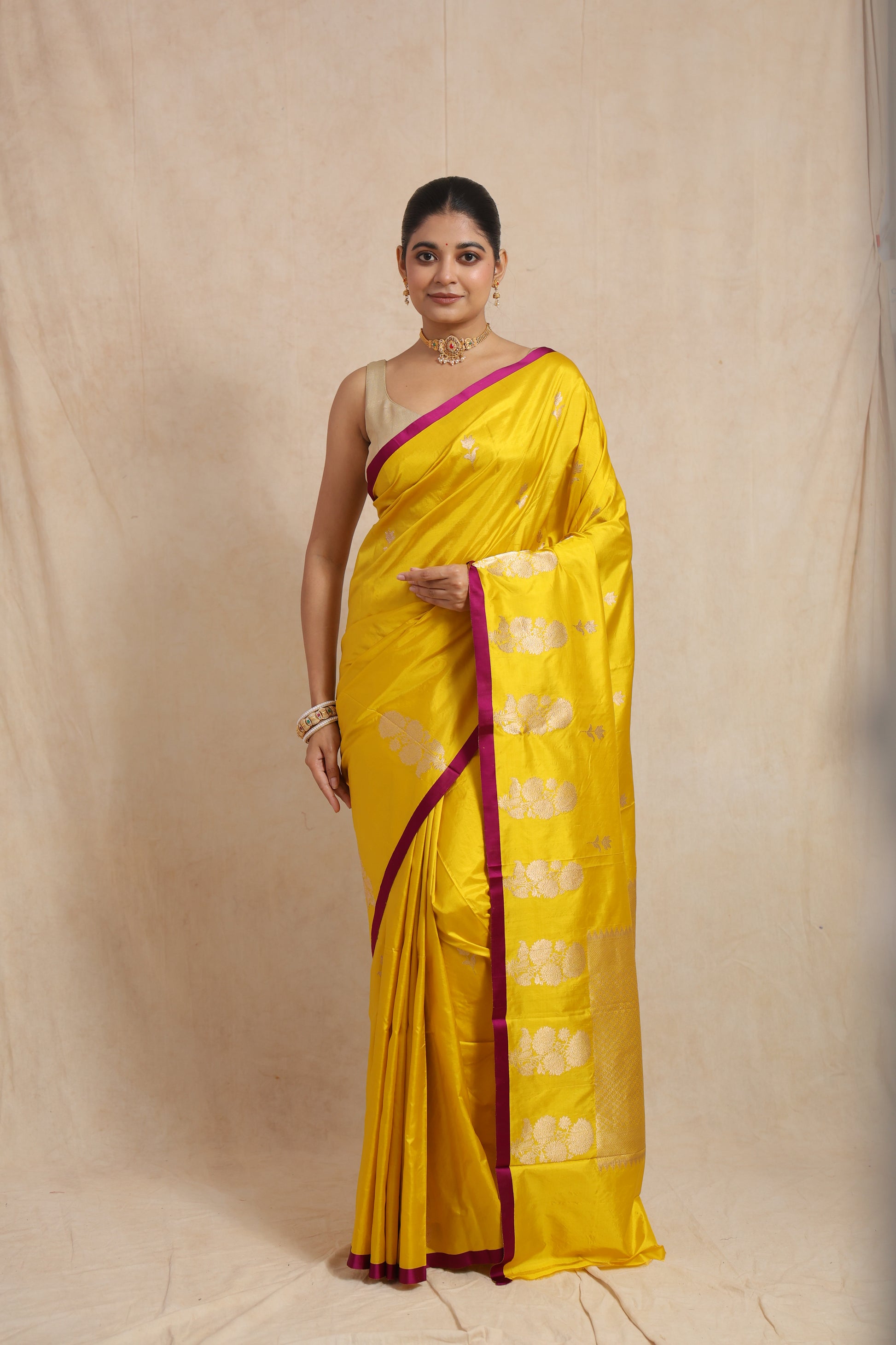 Model wearing sunshine yellow Banarasi silk saree with silver floral buttas