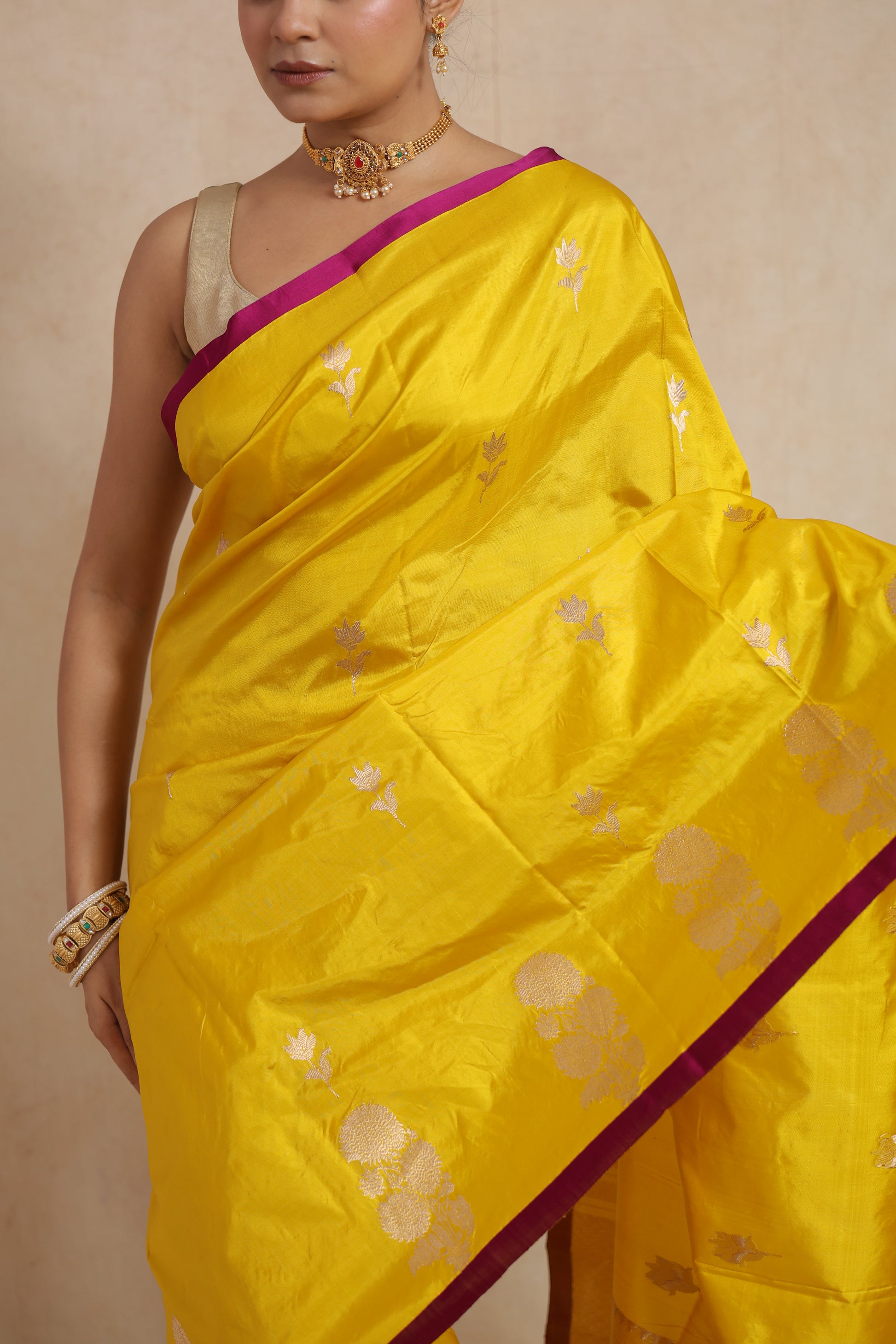 Close-up of sunshine yellow Banarasi silk saree highlighting silver floral motifs