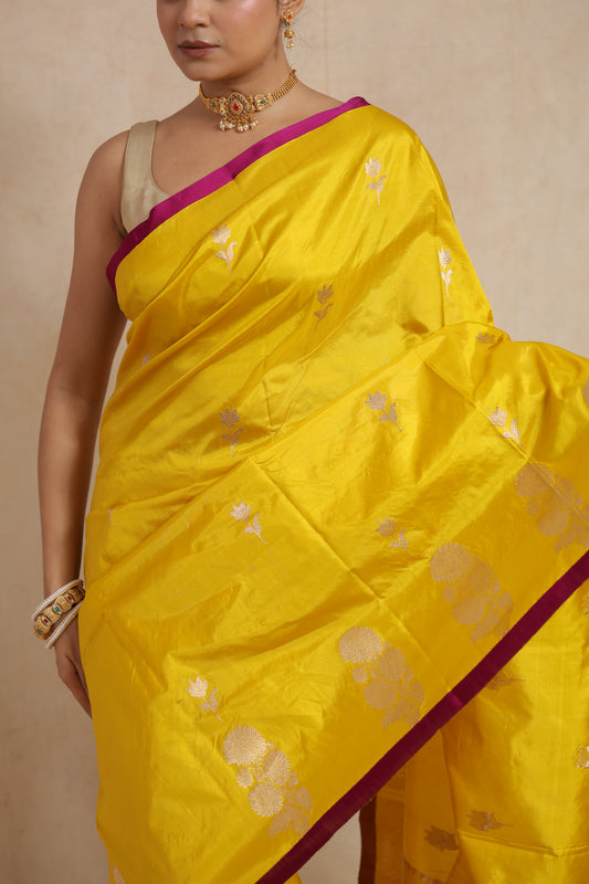 Close-up of sunshine yellow Banarasi silk saree highlighting silver floral motifs