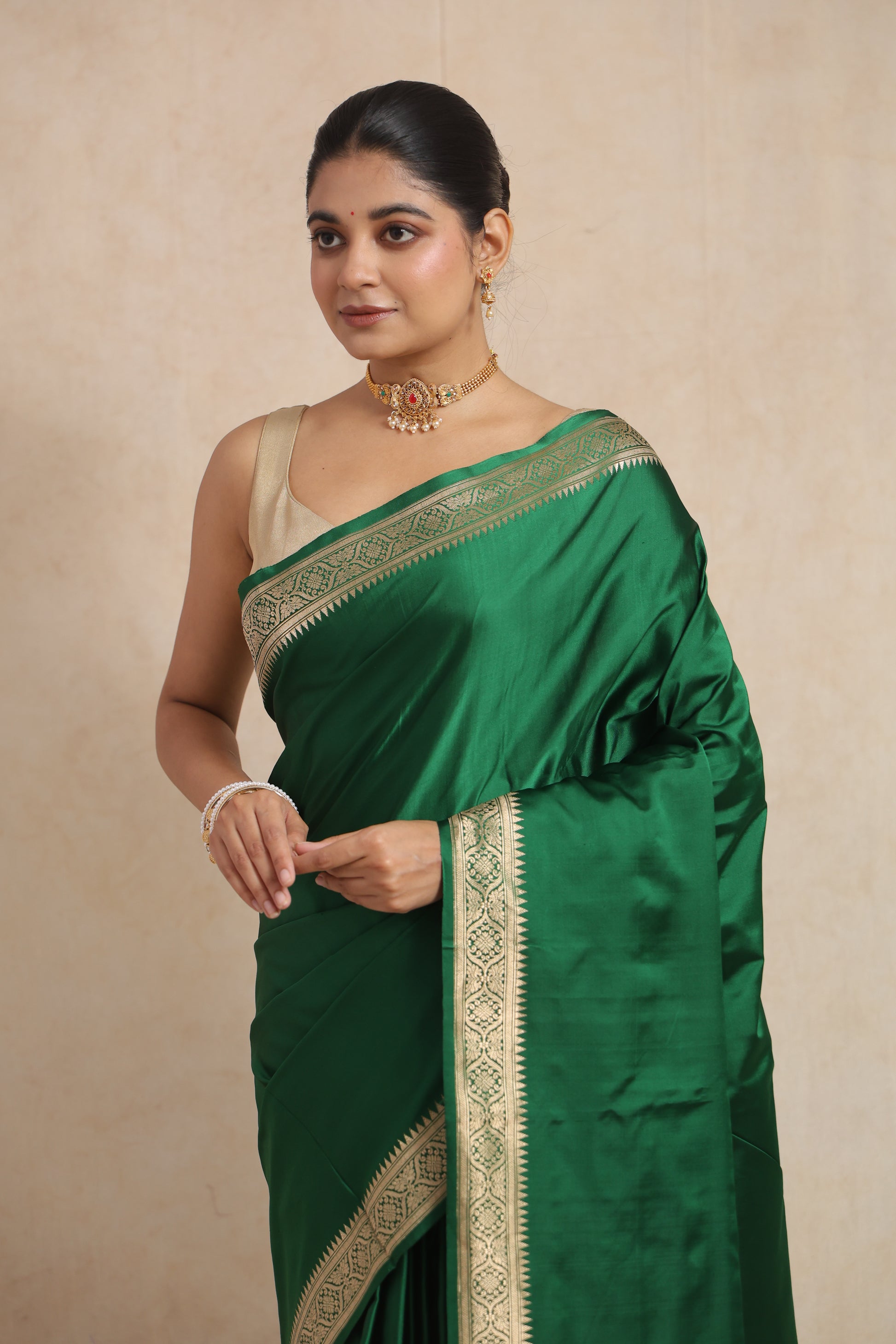 Close-up of emerald green Banarasi art silk saree featuring intricate woven border