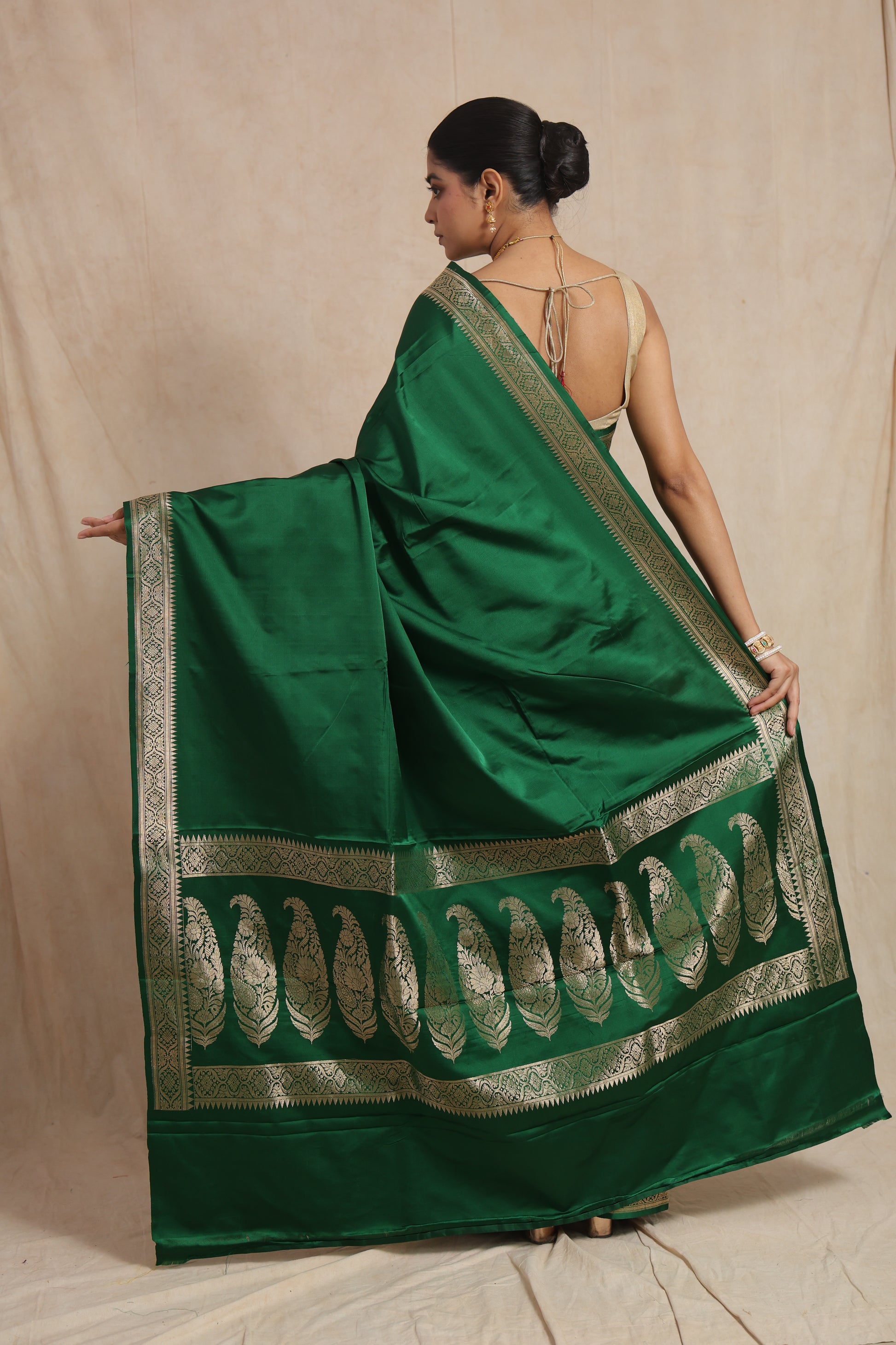Back view of emerald green Banarasi art silk saree highlighting traditional paisley woven pallu