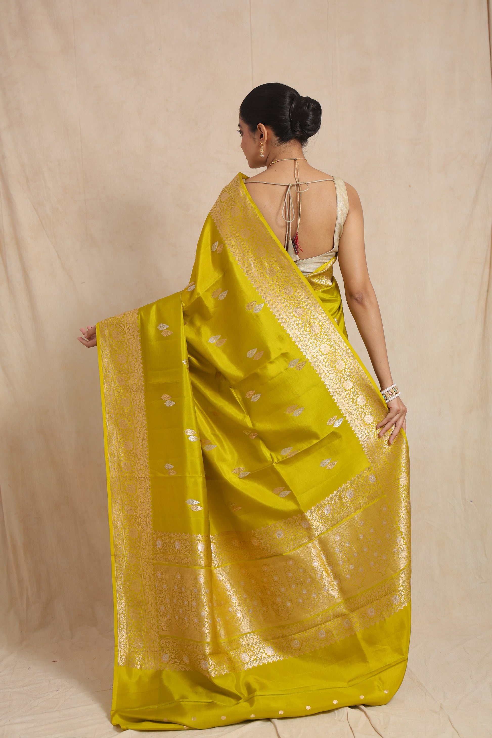 Back view of lime yellow Banarasi silk saree displaying the elegant pallu