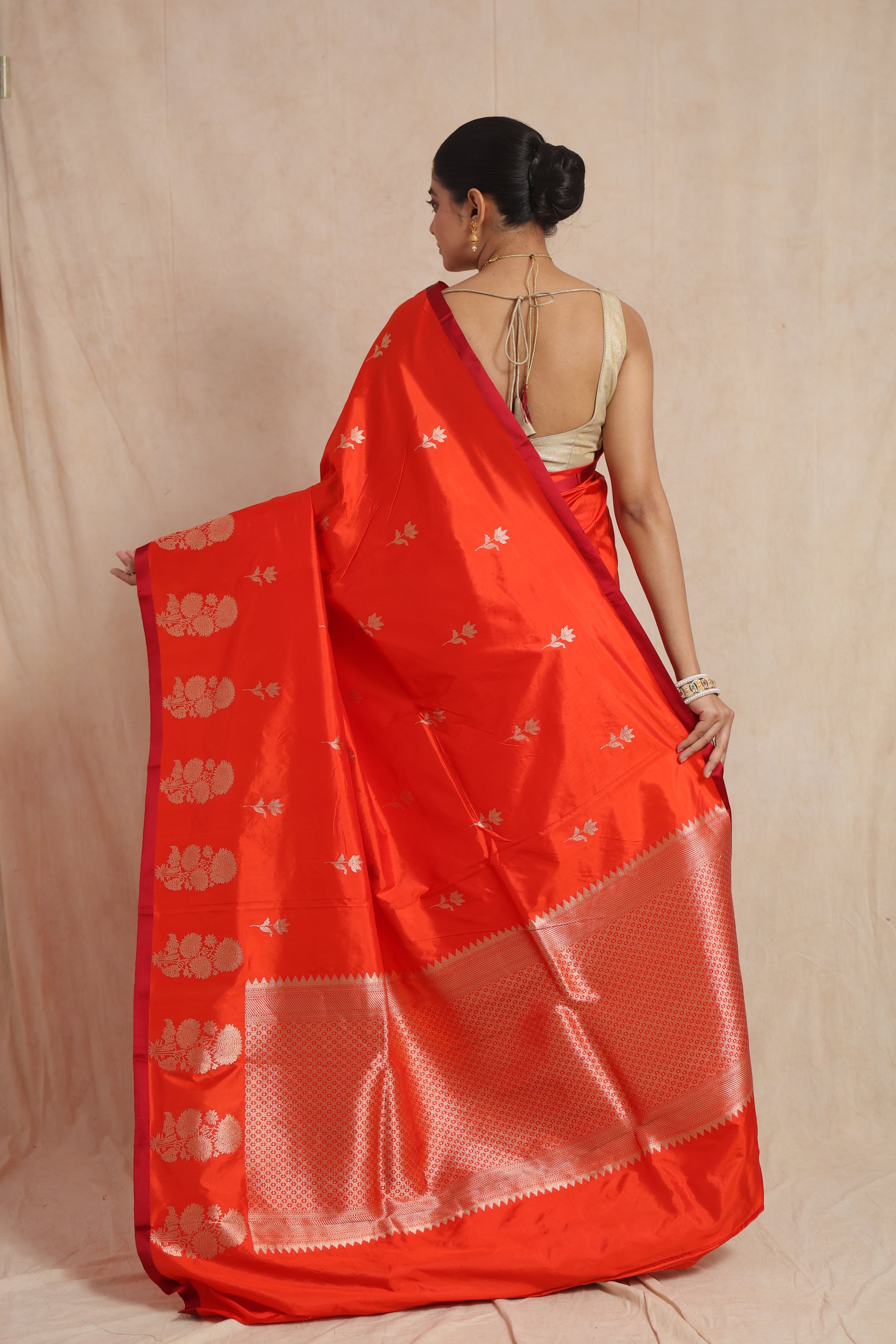 Back view showcasing the richly woven pallu of the vermilion Banarasi silk saree