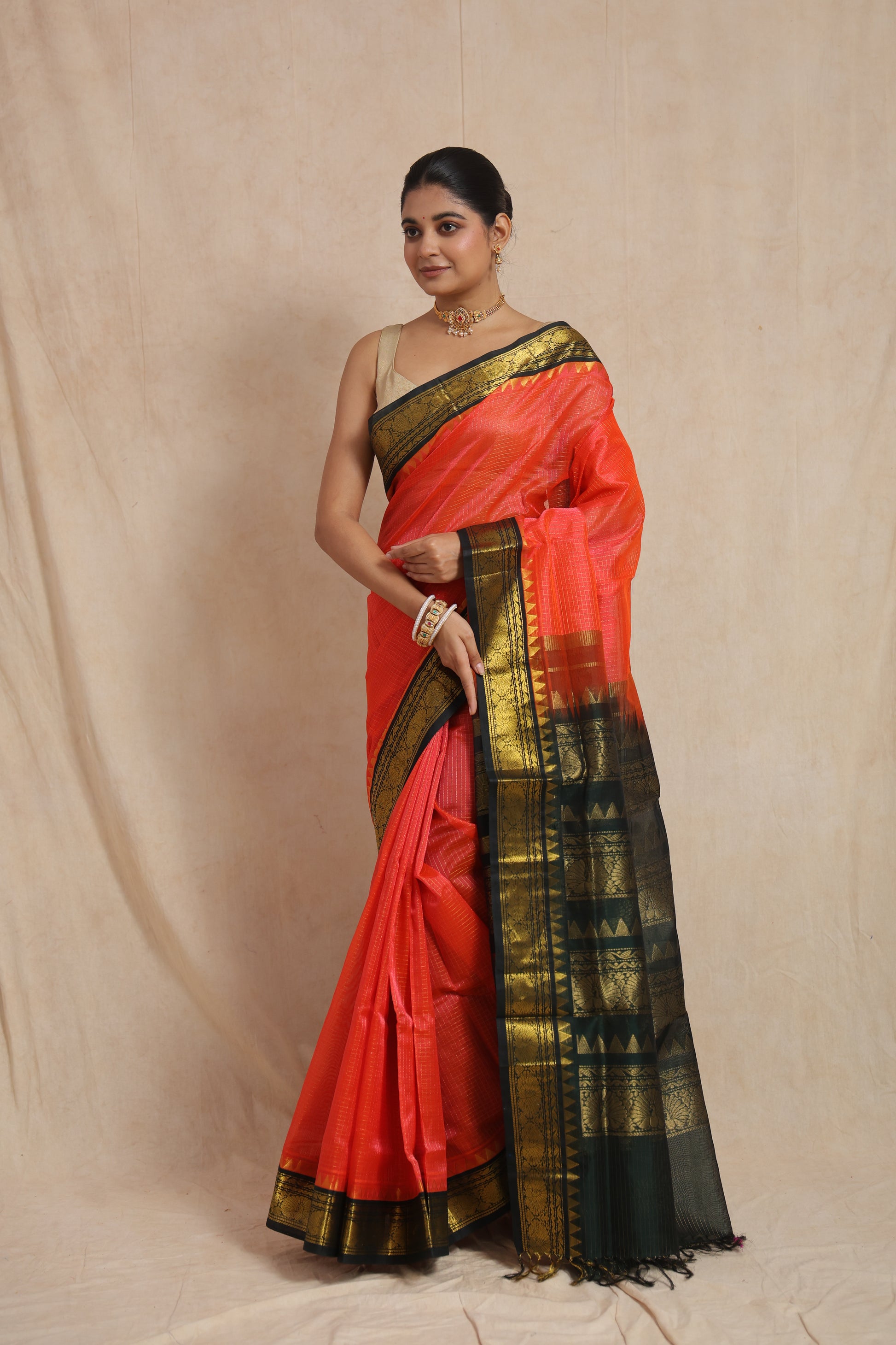 Front view of coral orange Kanchipuram Handloom SICO saree with black contrast border