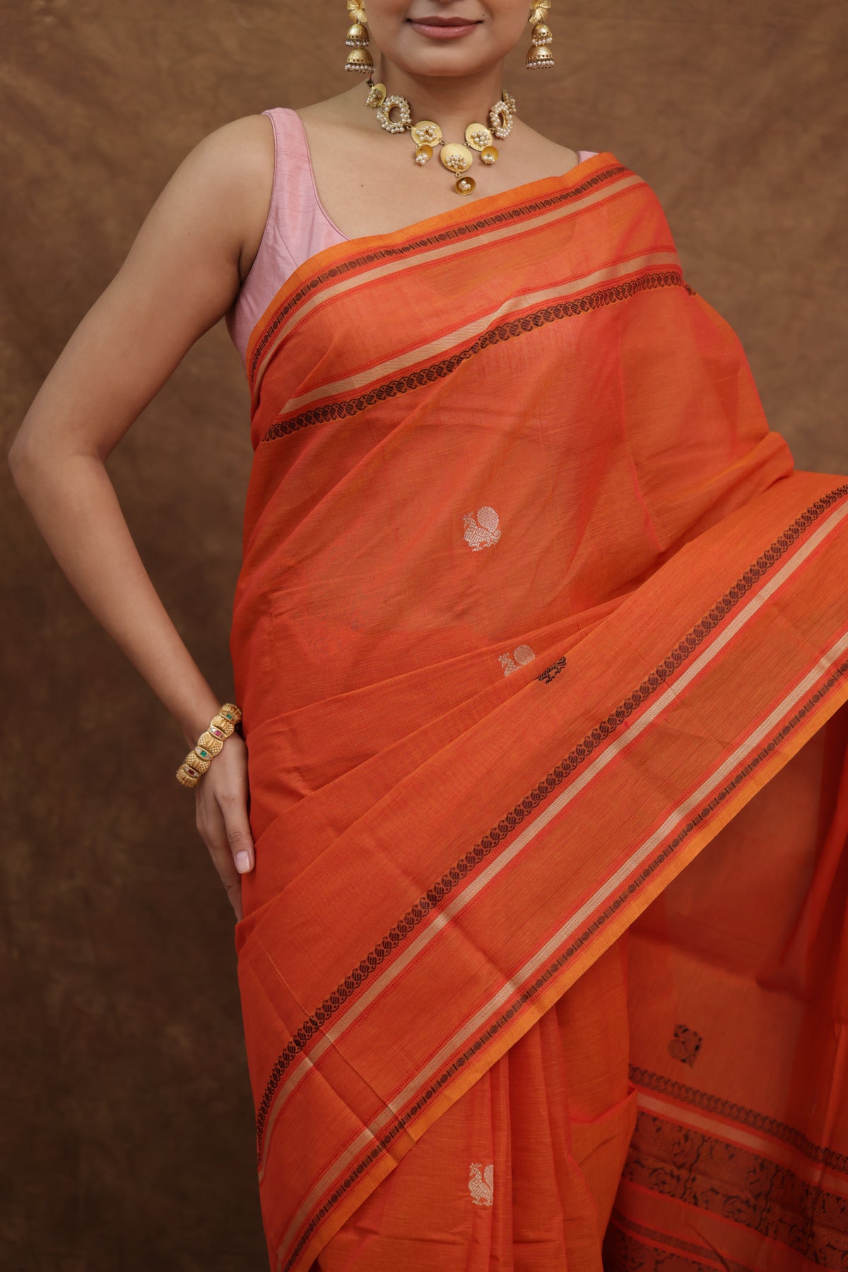Pink Kanchipuram cotton saree with traditional woven border, showcasing intricate craftsmanship and vibrant color from Joyee Kolkata.