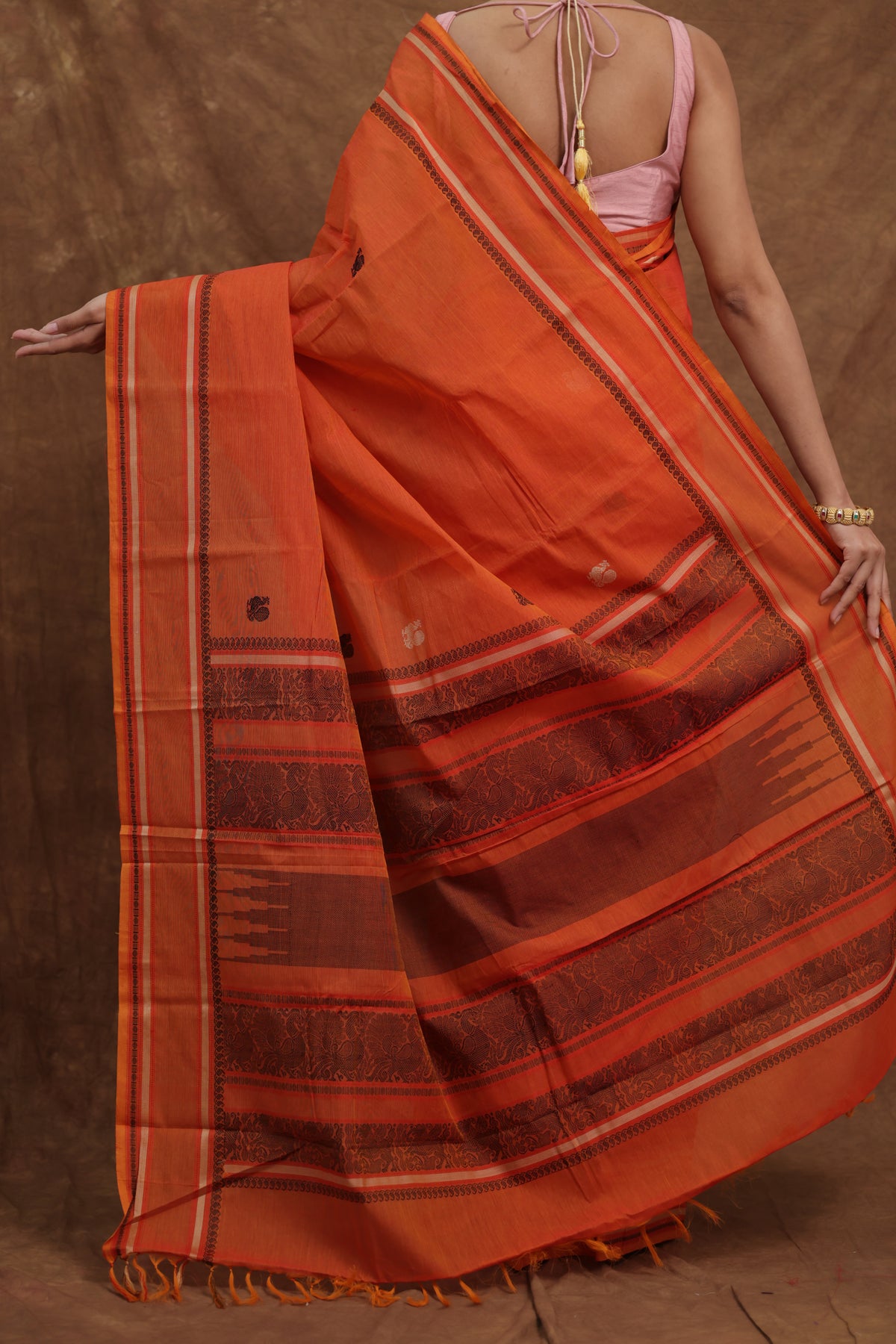 Pink Kanchipuram cotton saree with traditional woven border from Joyee Kolkata, featuring intricate craftsmanship and vibrant design.