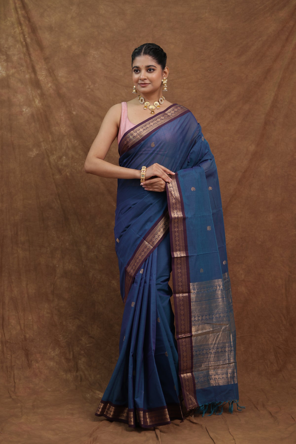 Denim blue Kanchipuram cotton saree with rust woven border, showcasing traditional craftsmanship and intricate weaving details.