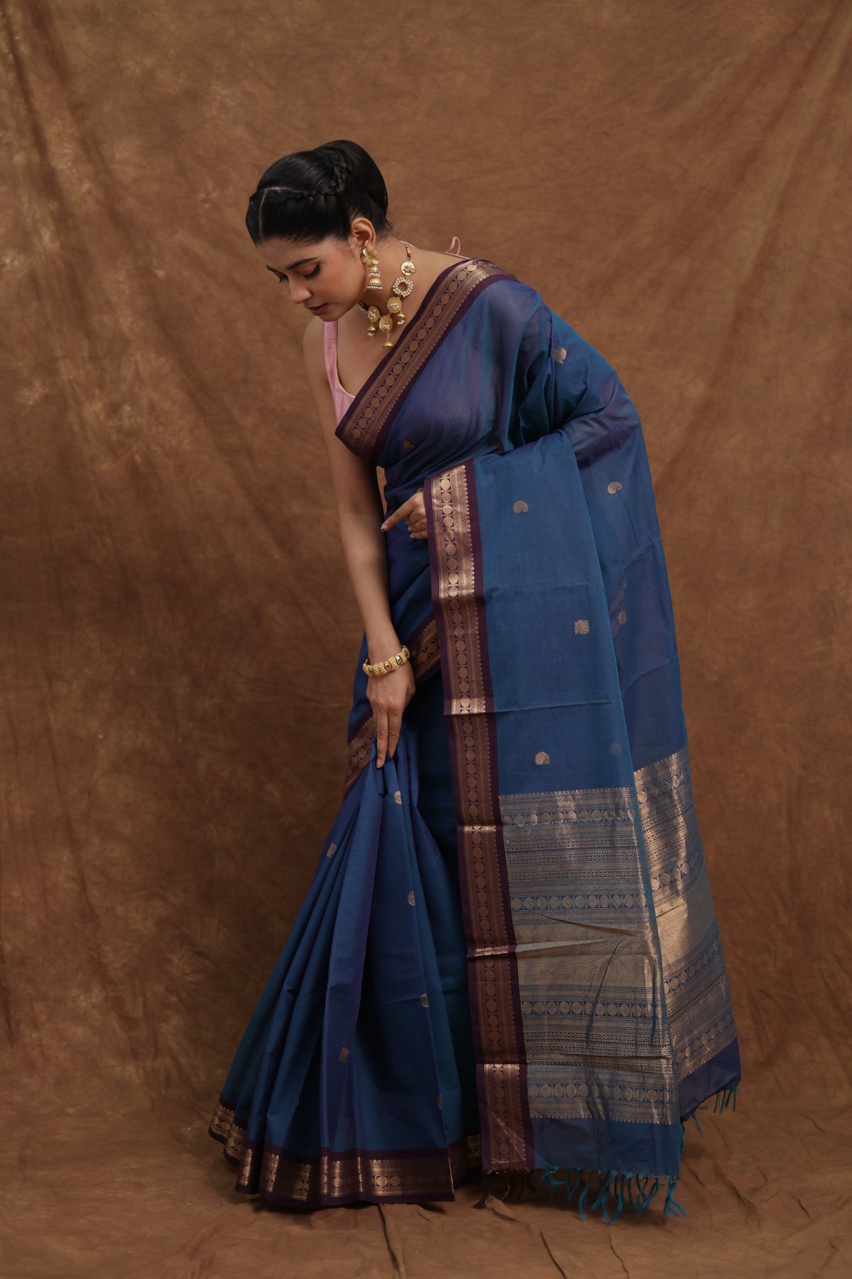 Blue Kanchipuram cotton saree with rust woven border from Joyee Kolkata, showcasing intricate traditional weaving and vibrant color.