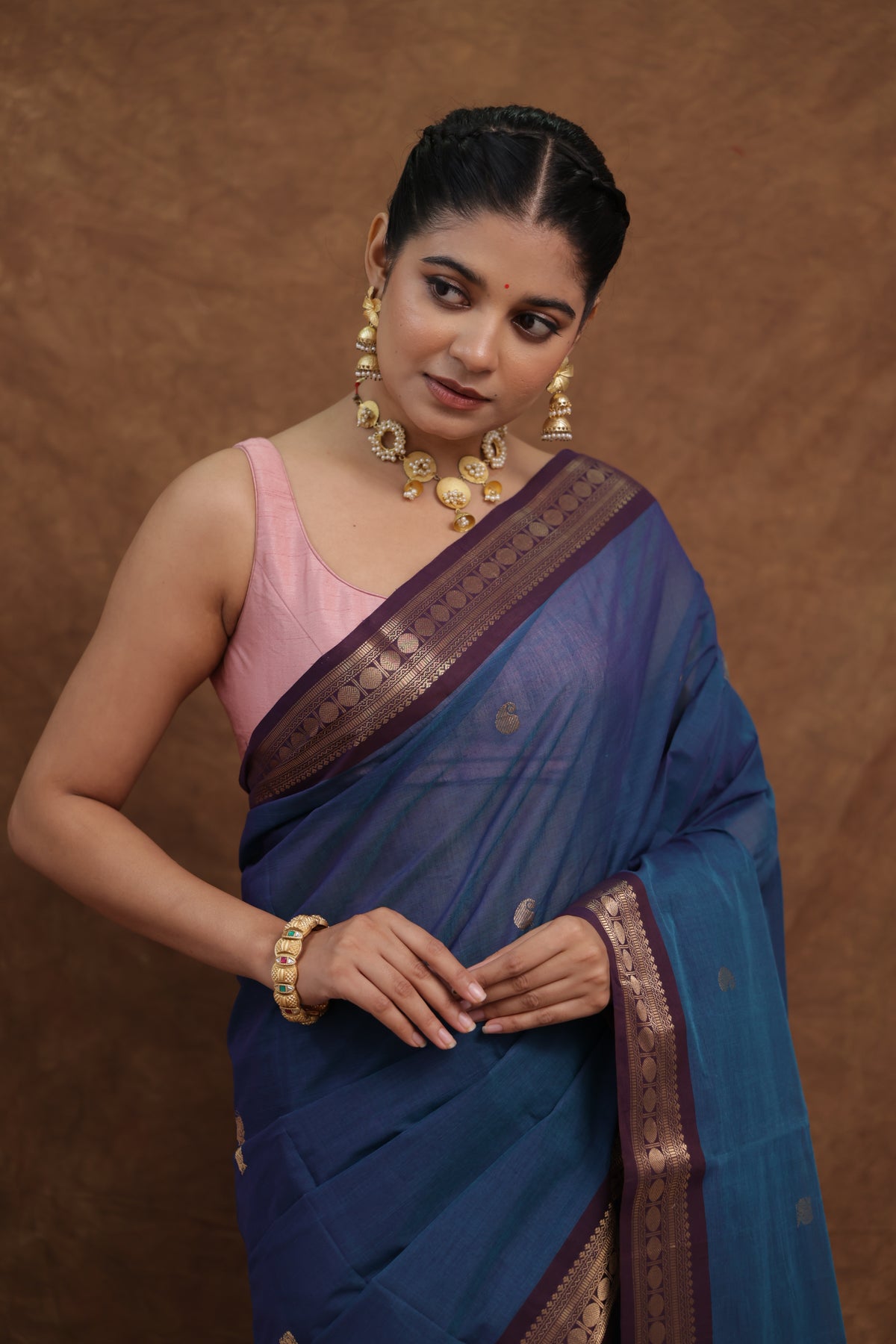 Blue Kanchipuram cotton saree with rust woven border, traditional denim blue sari by Joyee Kolkata, detailed woven design visible.