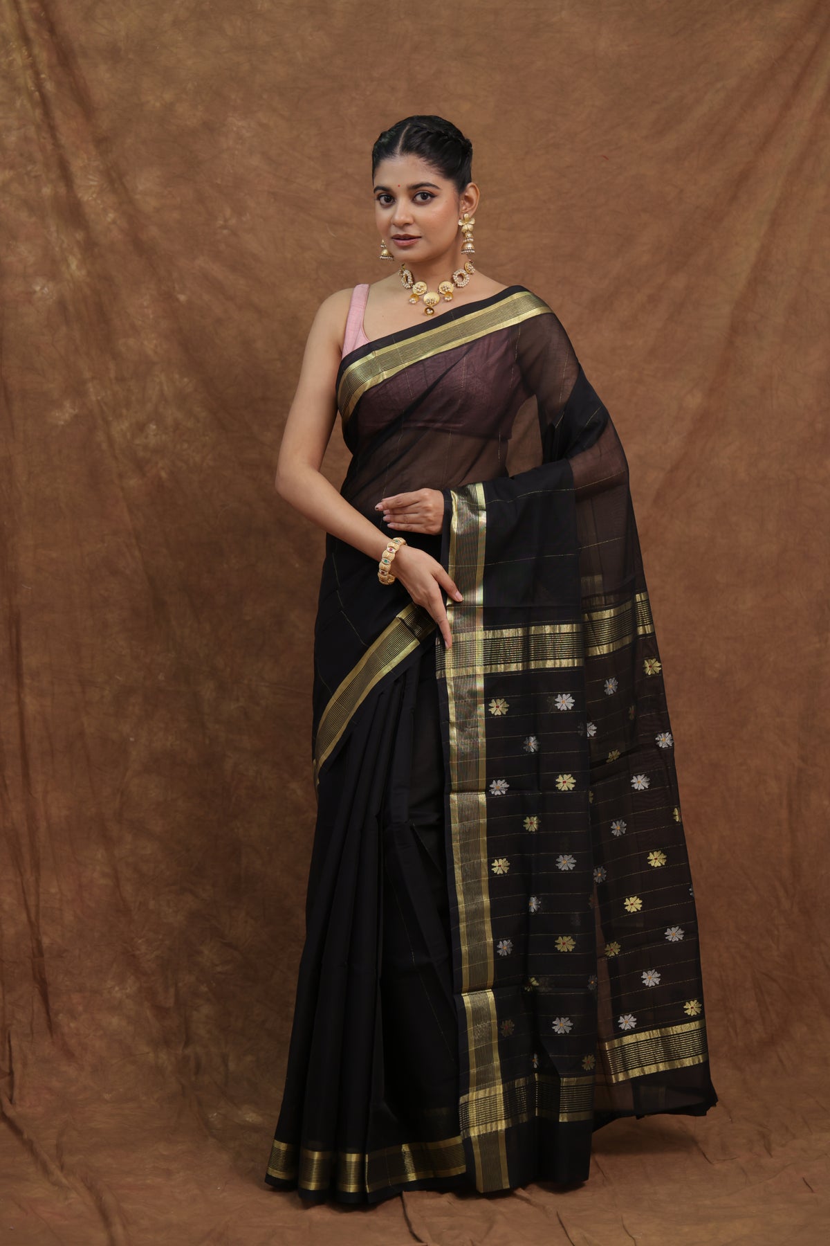 Elegant black Kanchipuram cotton sari with olive green border from Joyee Kolkata, showcasing intricate weaving and traditional design.