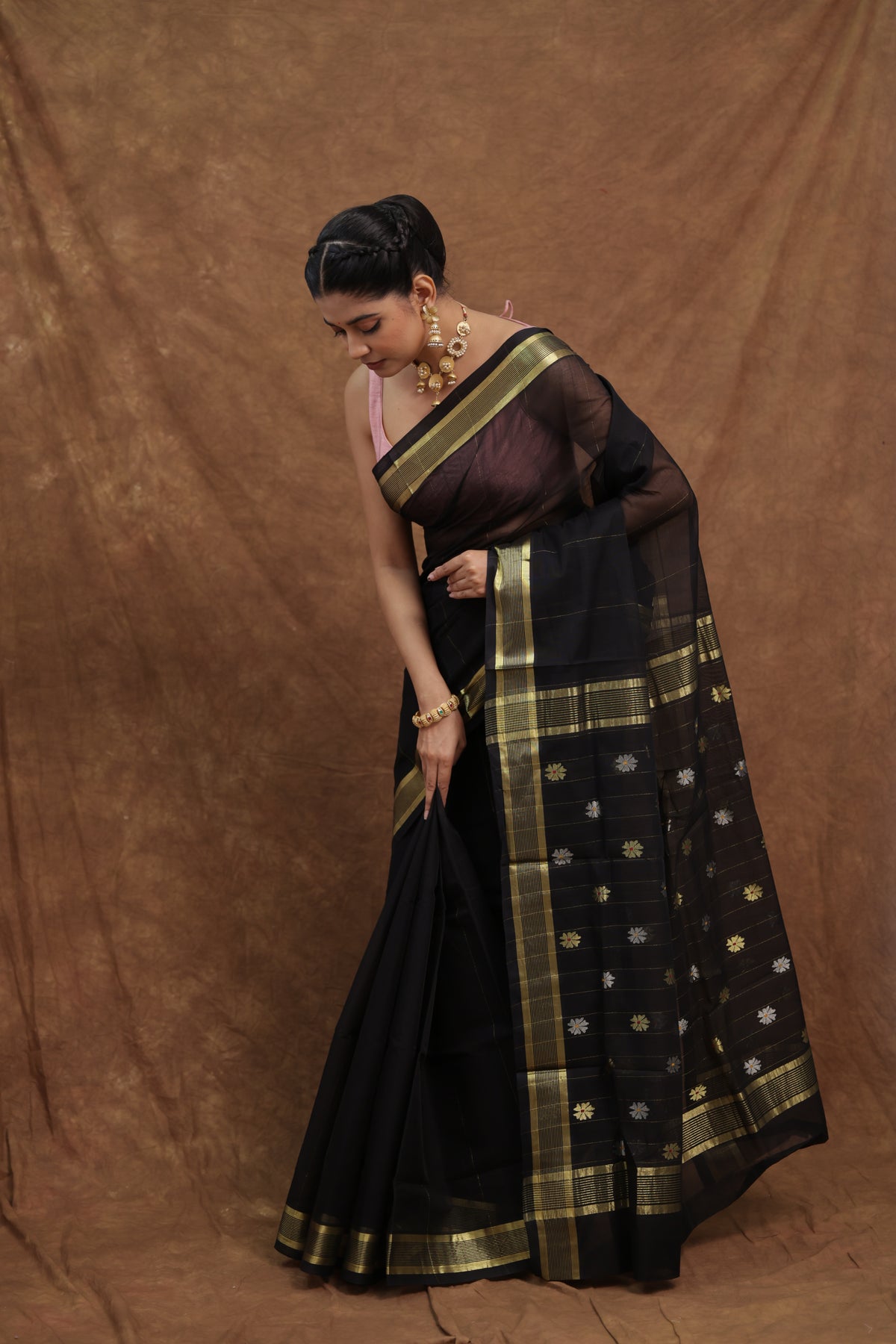 Elegant black Kanchipuram cotton saree by Joyee Kolkata with an olive green border and intricate woven details.