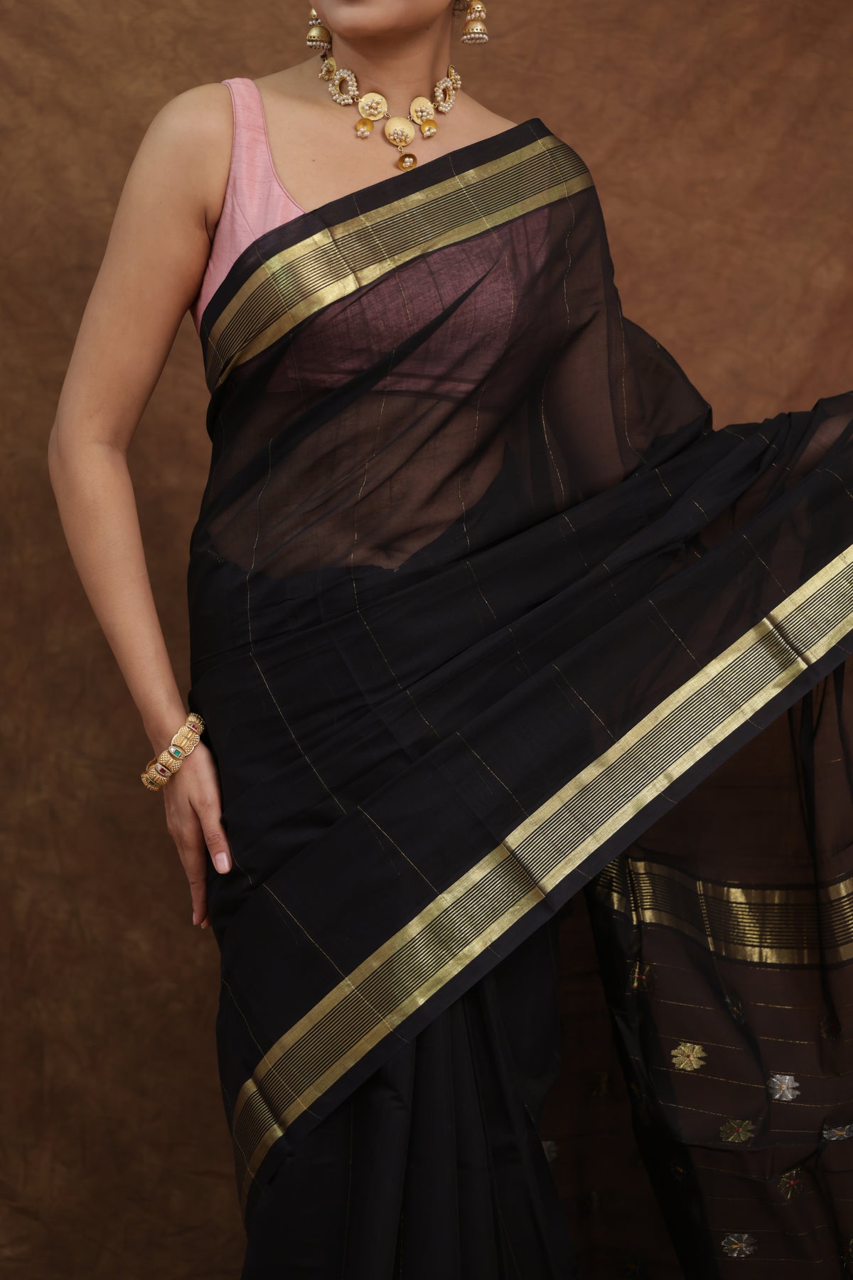 Black Kanchipuram cotton sari with olive green border, traditional saree from Joyee Kolkata showcasing intricate weaving and rich fabric.