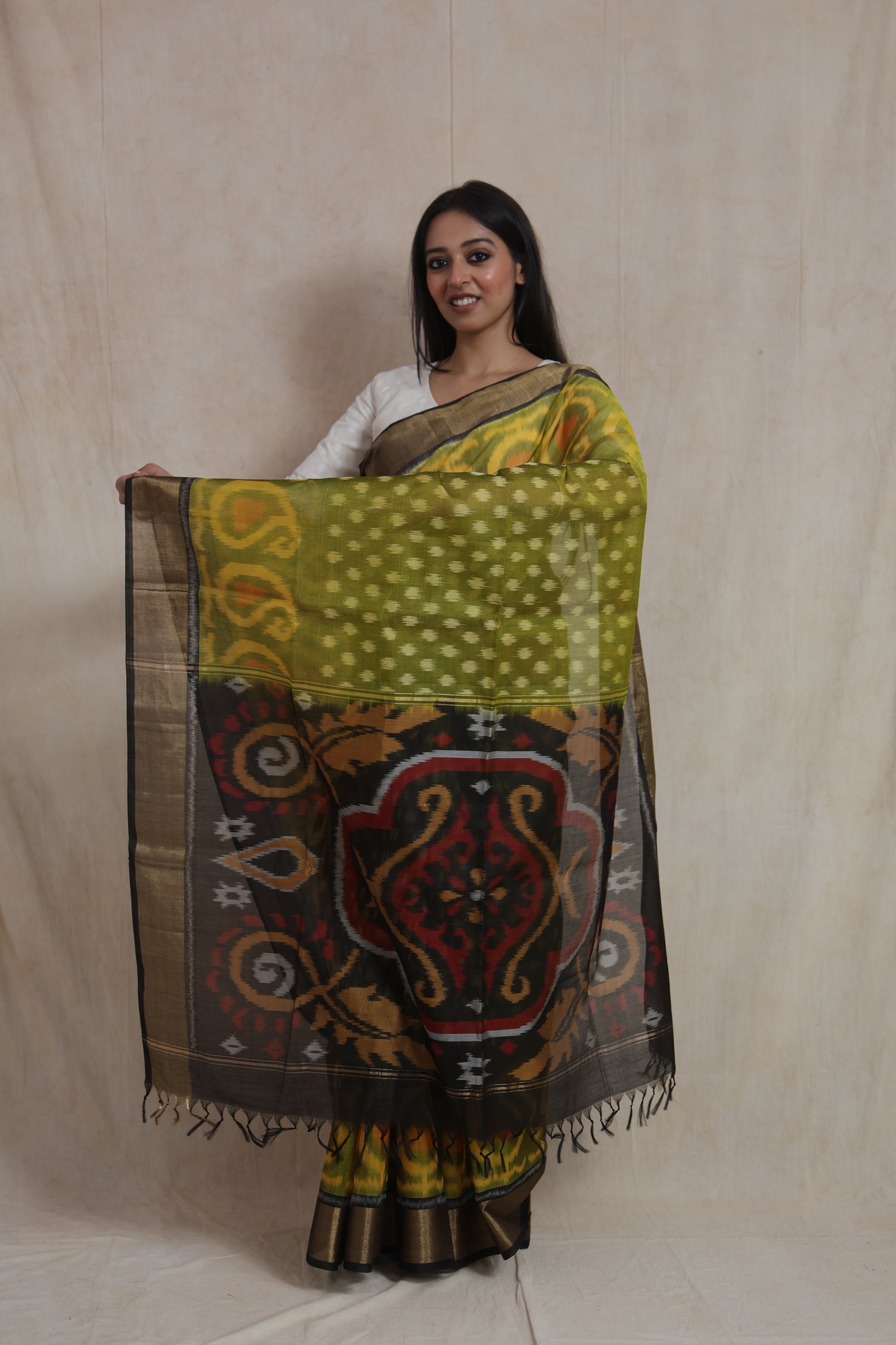 Detailed artistic pallu design of olive green Pochampally silk cotton saree with traditional woven motifs