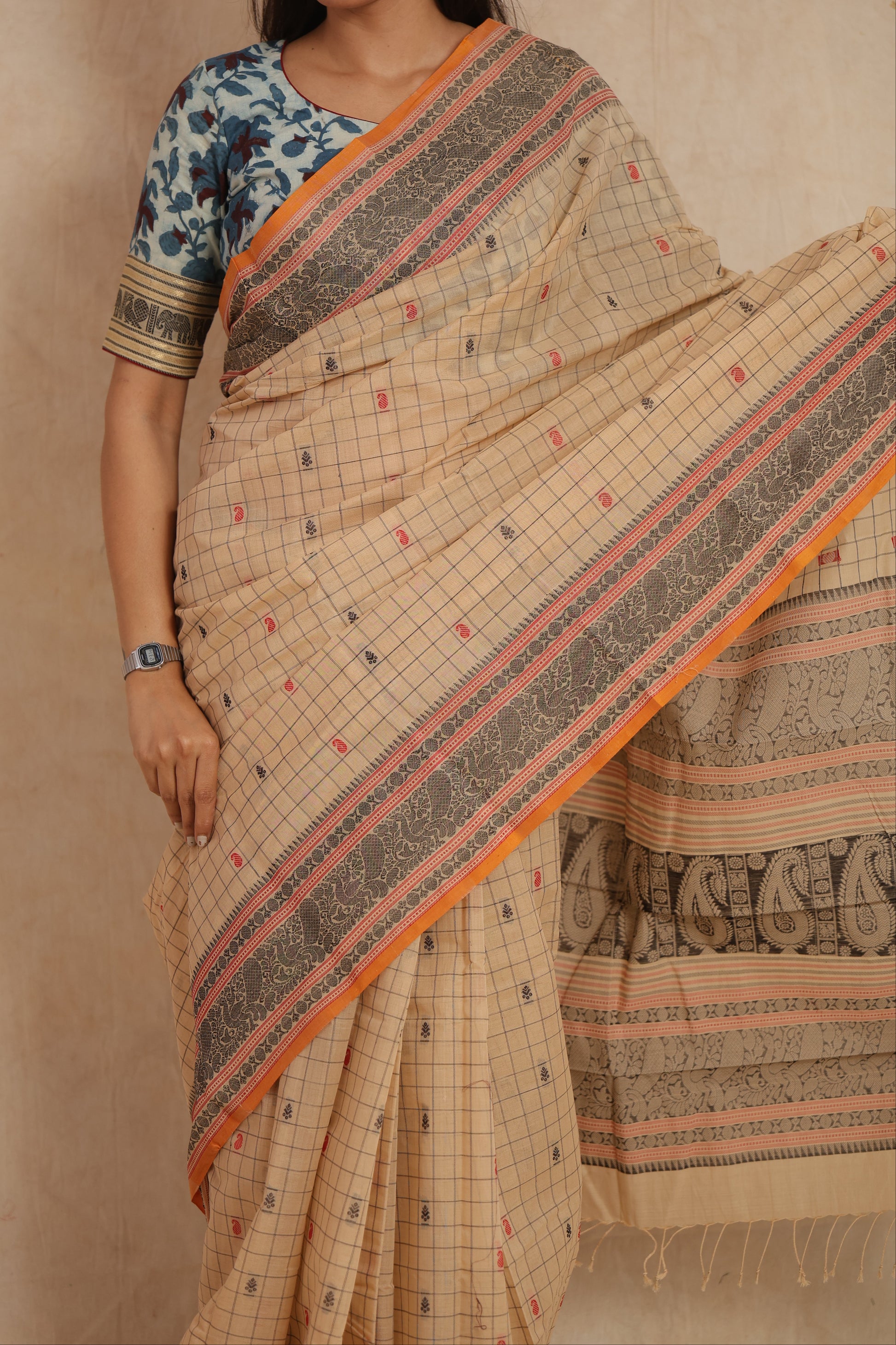 Close-up of beige Kanchipuram cotton saree with intricate woven border and checks