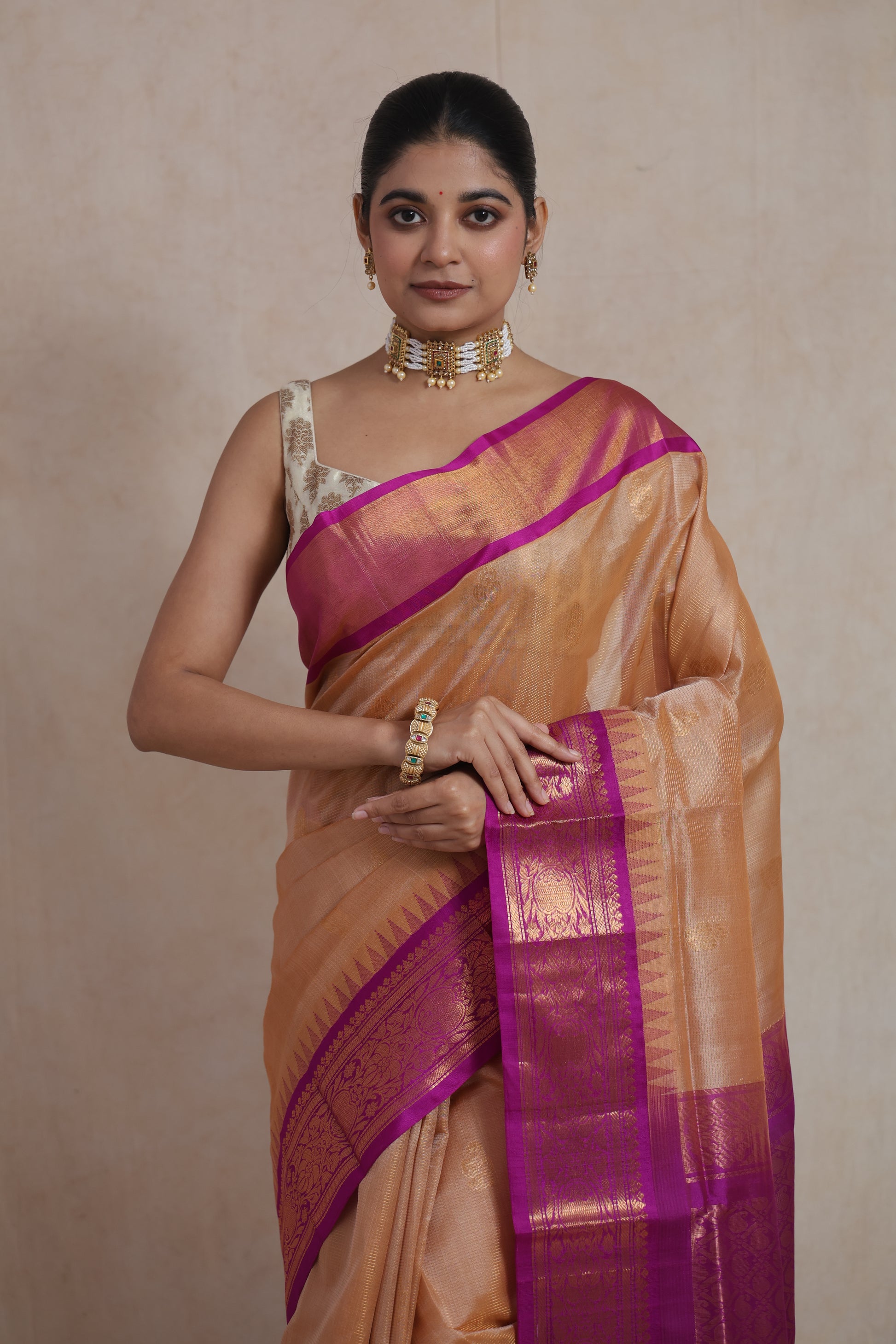 Front portrait of golden beige Kanchipuram Sico saree with rich magenta pallu