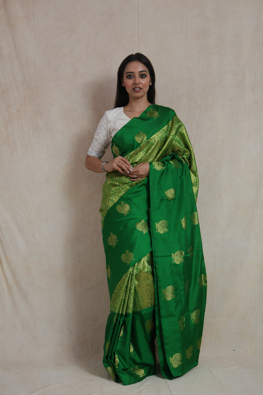 Full-length view of emerald green Kanjivaram silk saree showcasing elegant woven motifs and luxurious drape