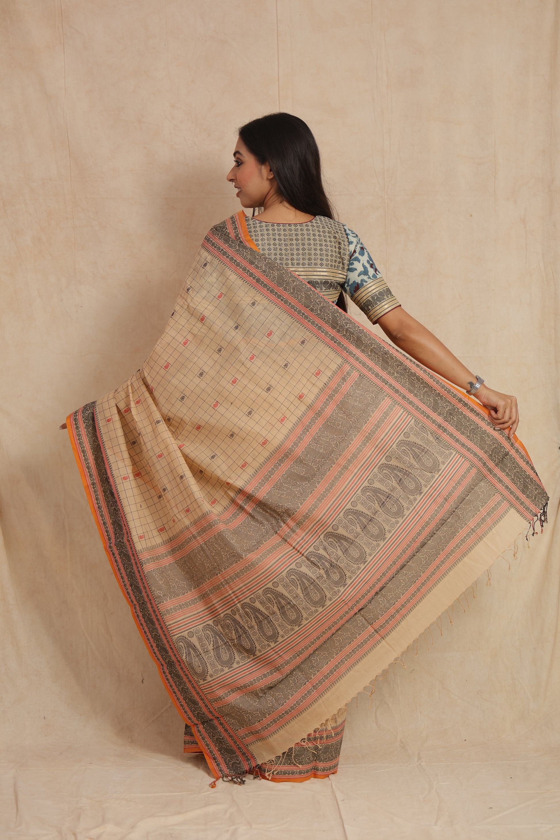 Back drape view of beige Kanchipuram cotton saree with woven paisley pallu