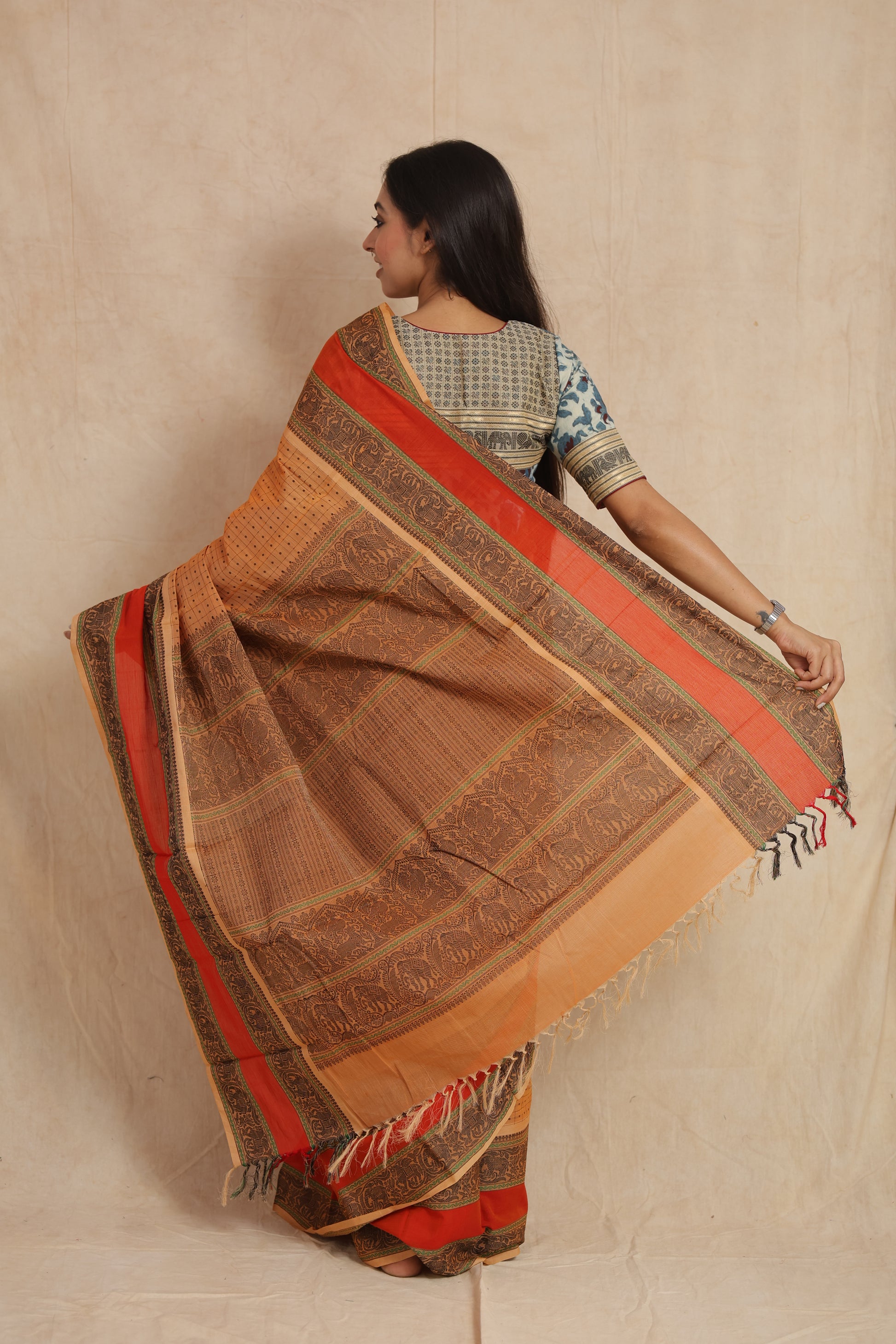 Back view of beige Kanchipuram cotton saree showcasing detailed woven pallu