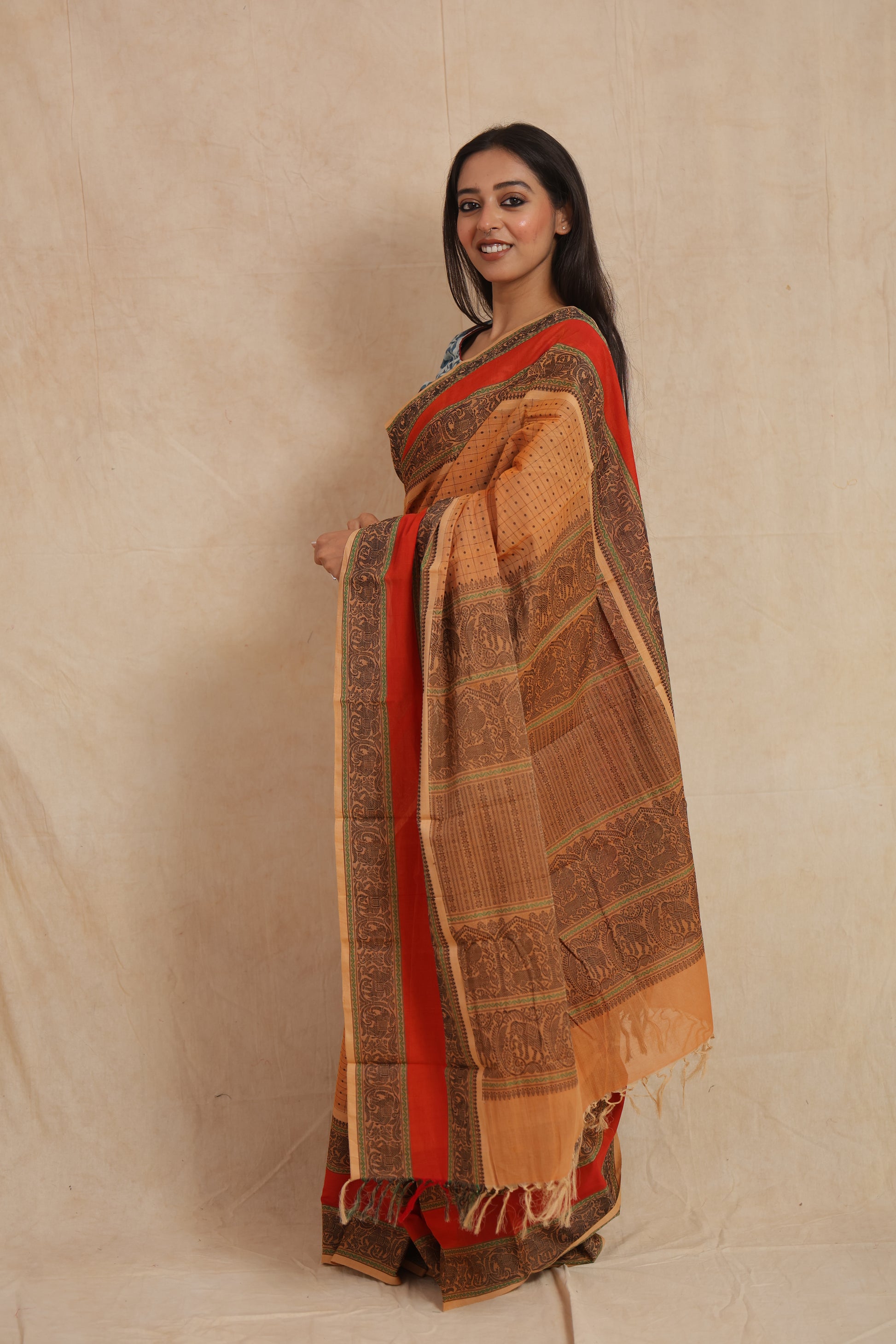 Side profile of beige Kanchipuram cotton saree with ornate pallu and tassels