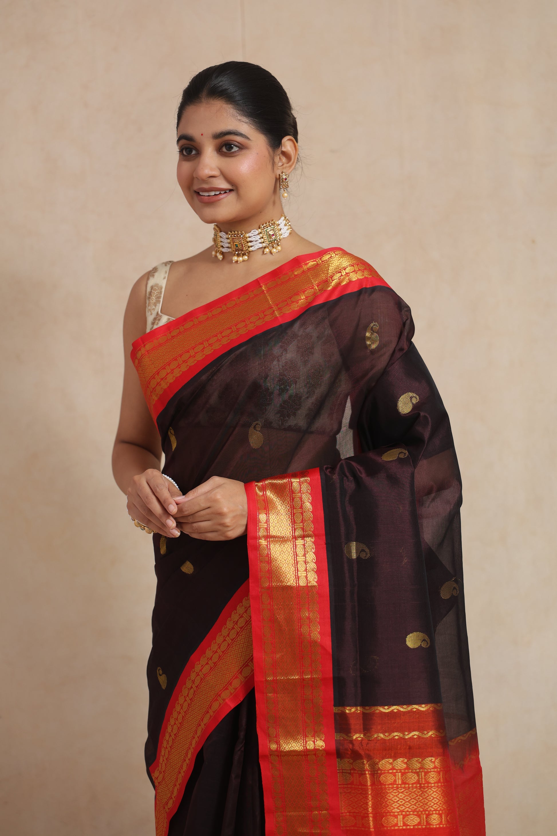Close-up of black Kanchipuram Sico saree with golden paisley motifs and zari border