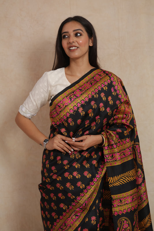 Close-up view of black Batik silk saree with floral buttas and pink border