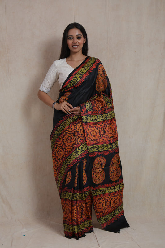 Model wearing midnight black Batik silk saree with rust orange paisley and floral motifs