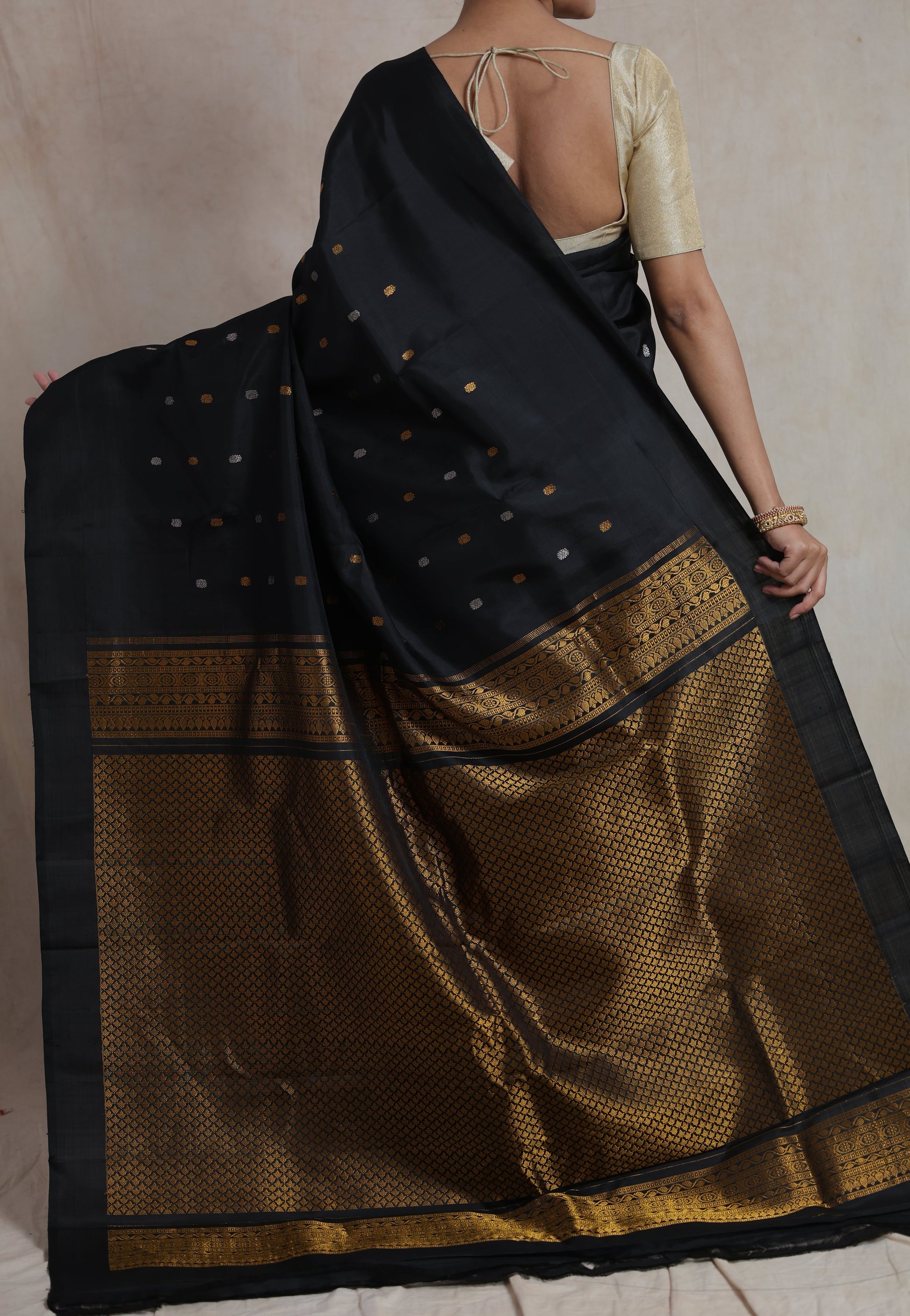 Close up of black Gadwal silk saree with gold buttas and border