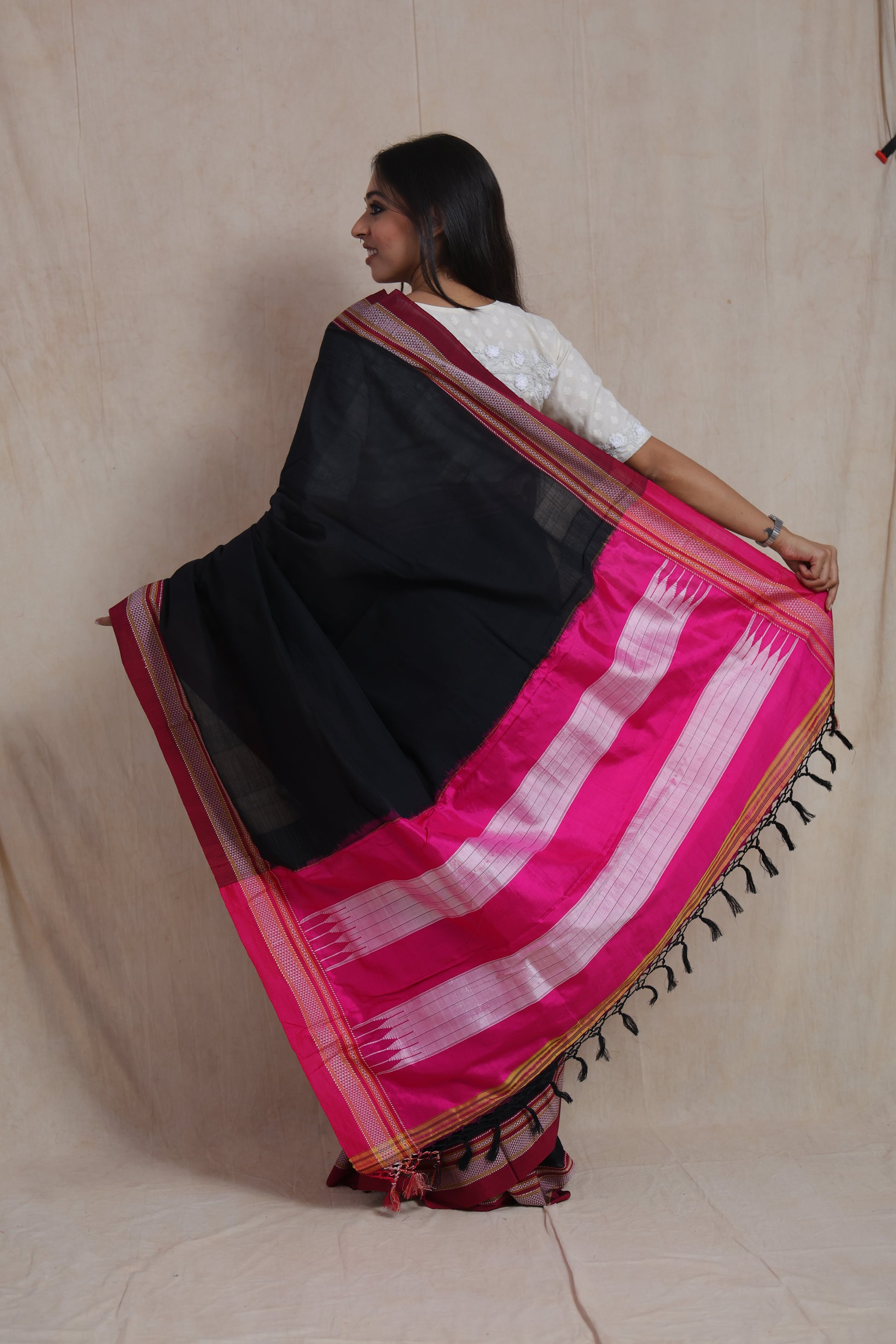 Back pallu view of black Ilkal cotton saree with vibrant pink contrast pallu