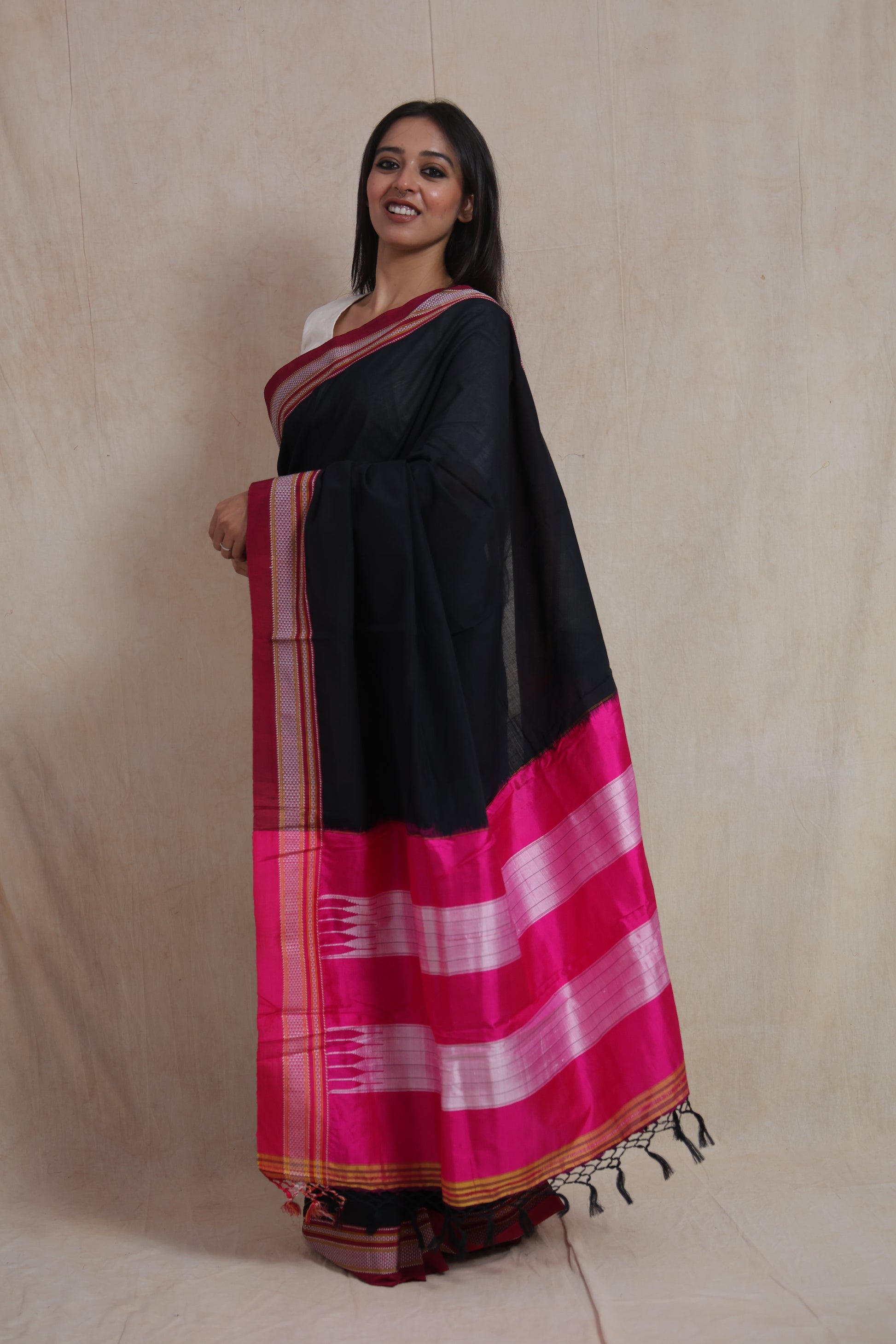 Side standing pose showcasing pink contrast pallu of Ilkal cotton saree