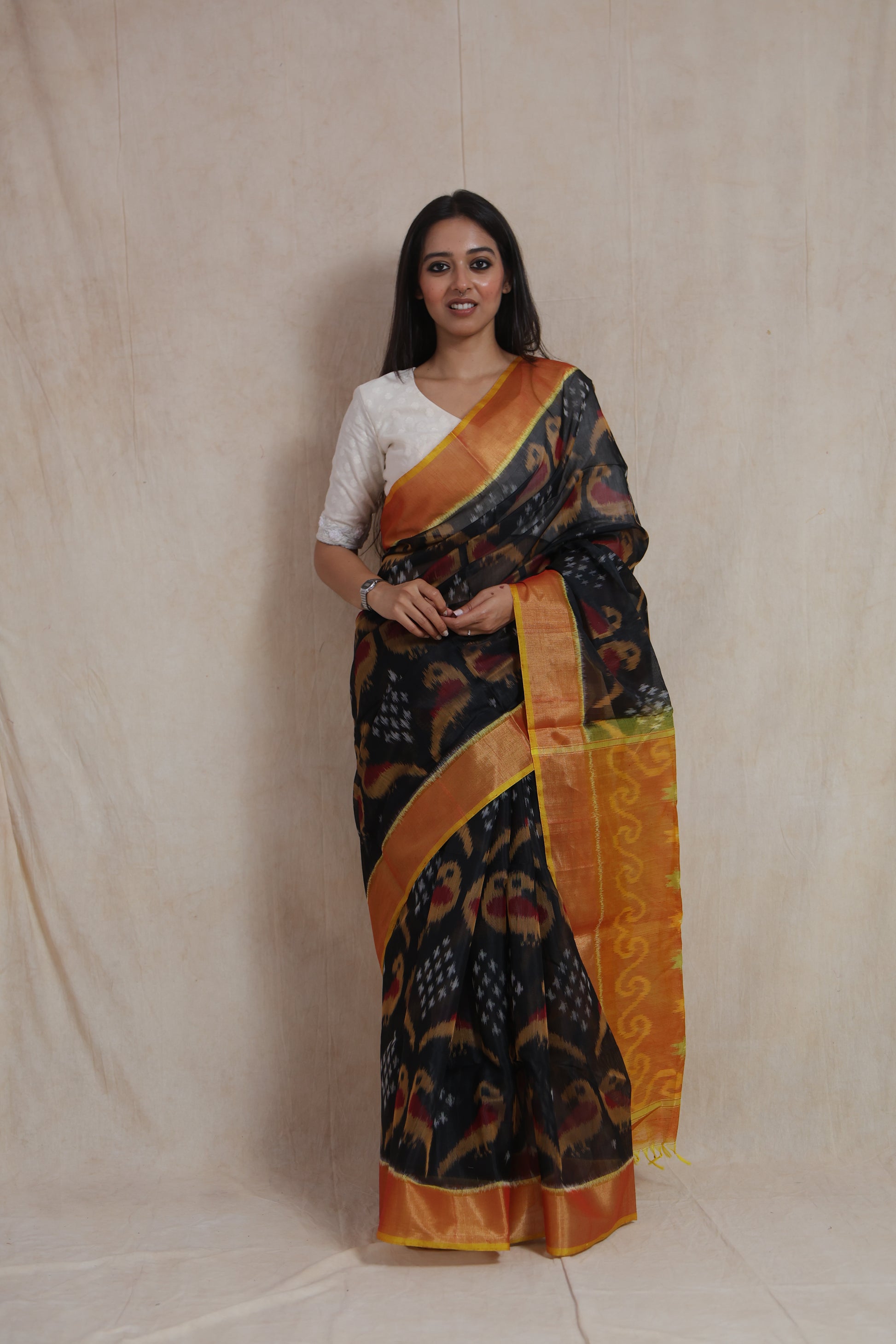 Full-length view of Panchampali silk cotton saree with black body and vibrant orange patterned pallu