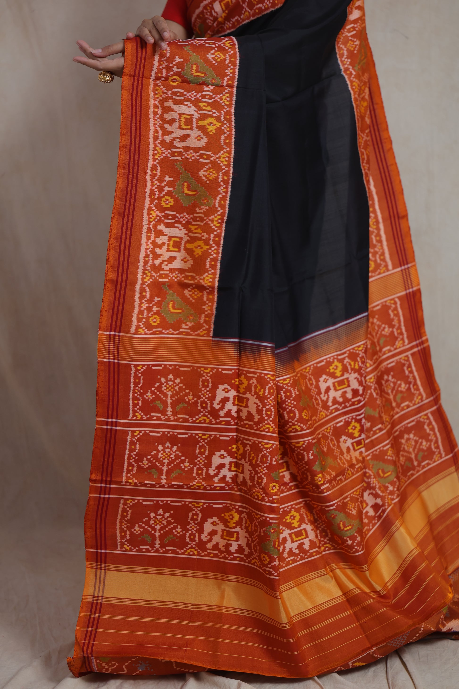 Close-up of woven rust orange border on black Patola silk saree