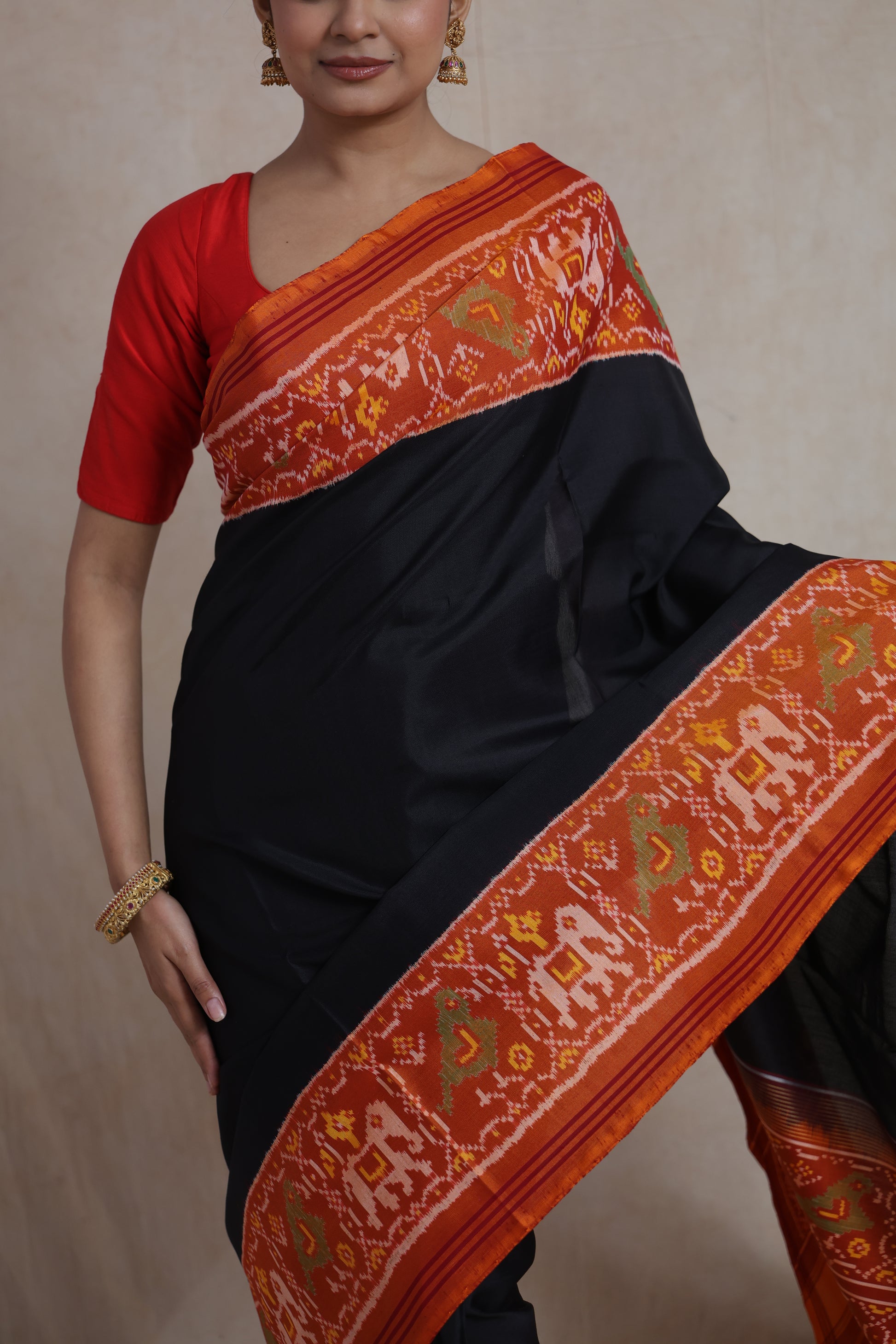 Front drape view of black Patola silk saree with traditional ikat motifs