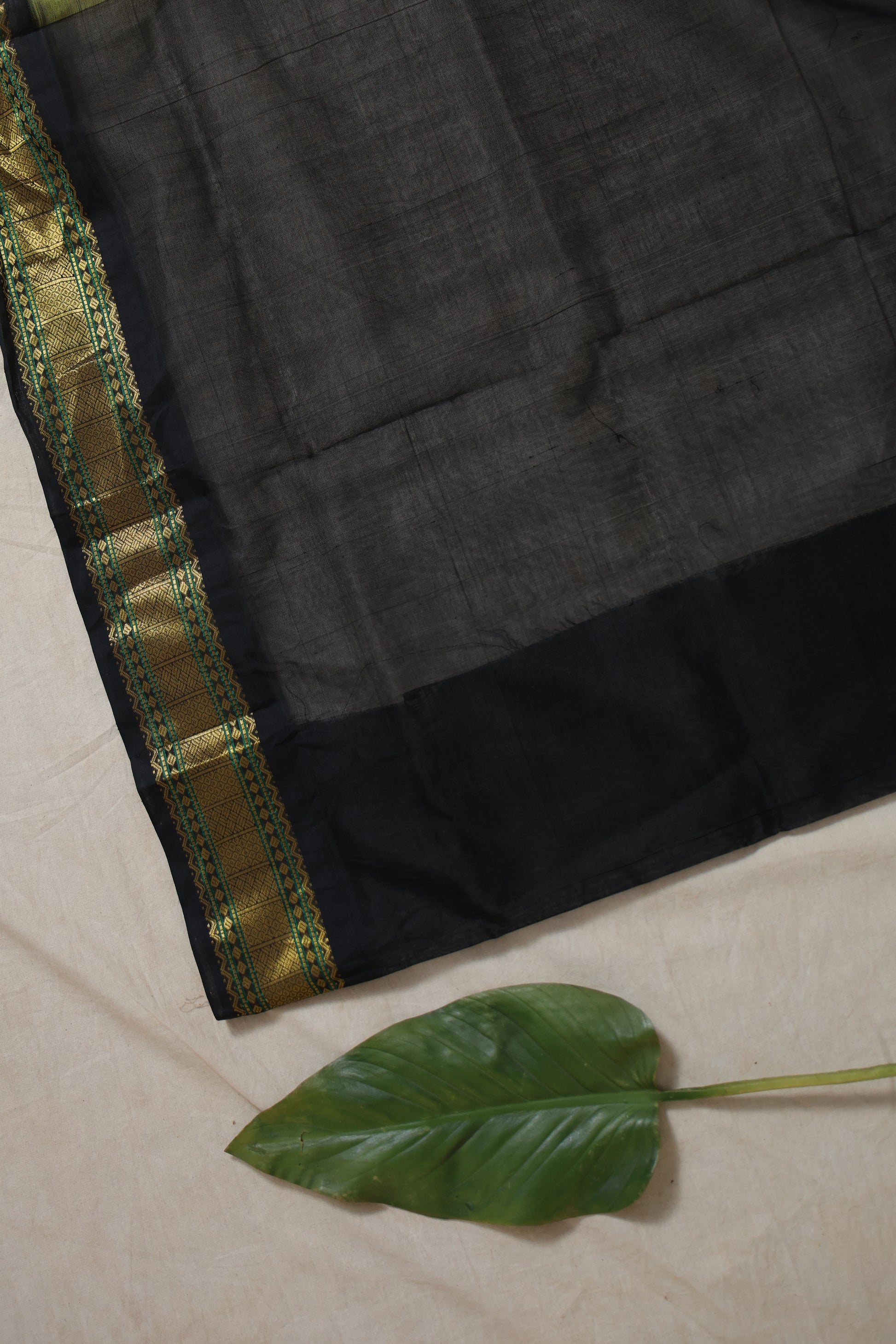Black zari pallu close-up with intricate weaving design