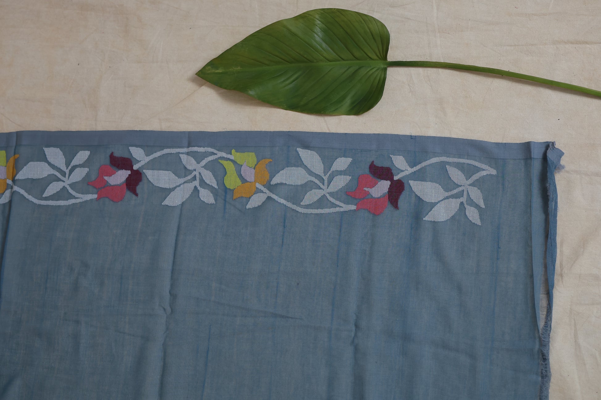 Close-up border detail of dusty blue Bengal Fulia cotton saree with floral motifs