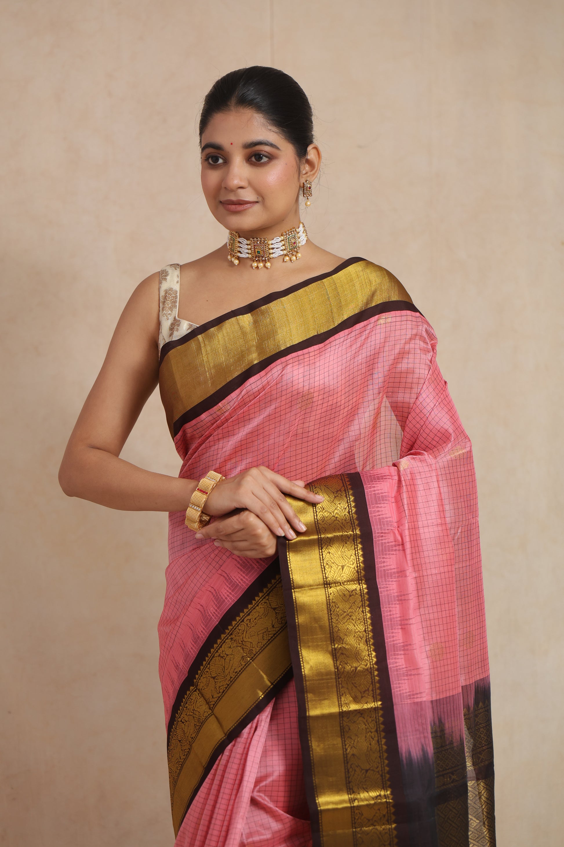 Close-up of blush pink Kanchipuram Sico saree with fine check weave and gold border