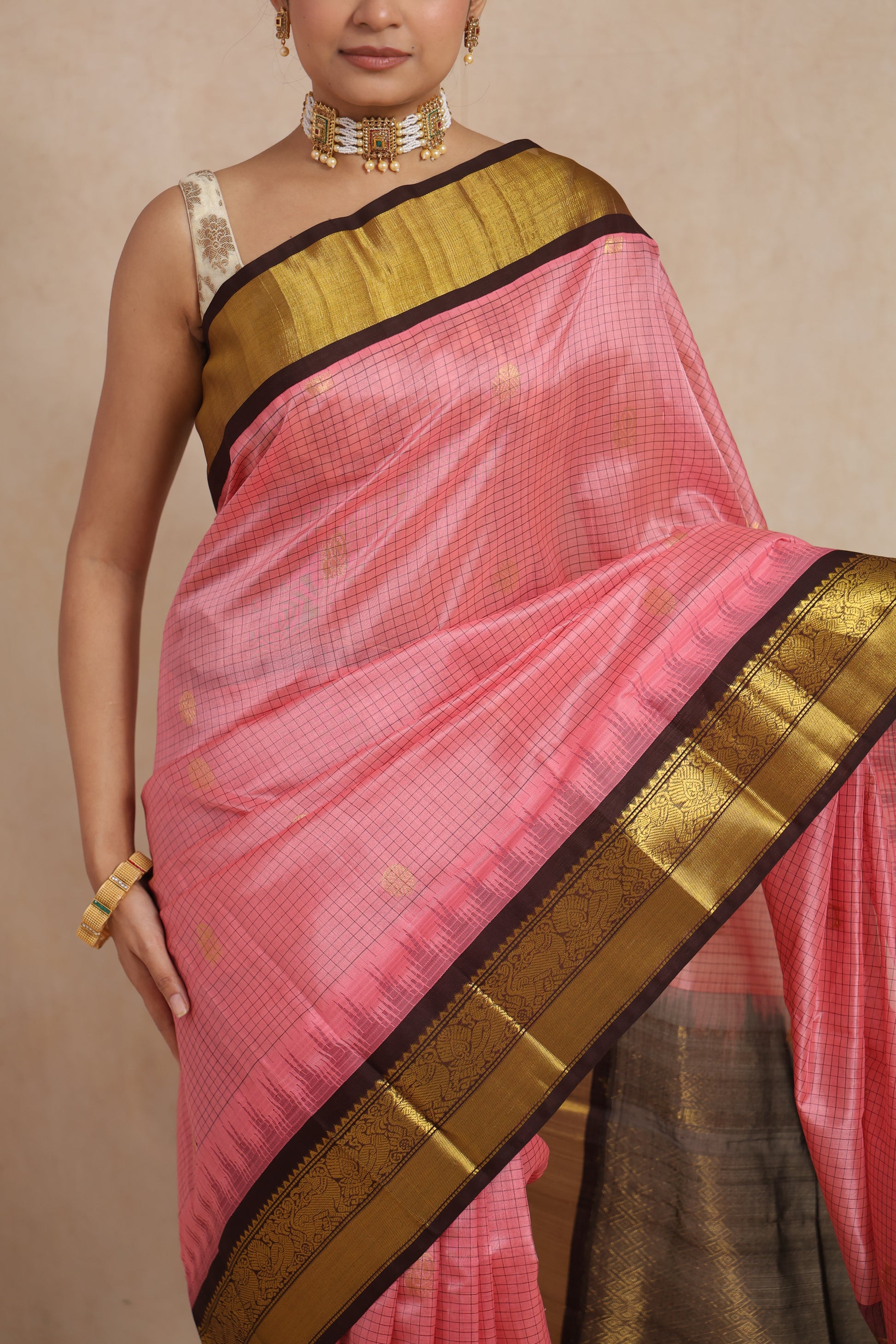 Elegant drape style of blush pink Kanchipuram Sico saree with traditional woven border
