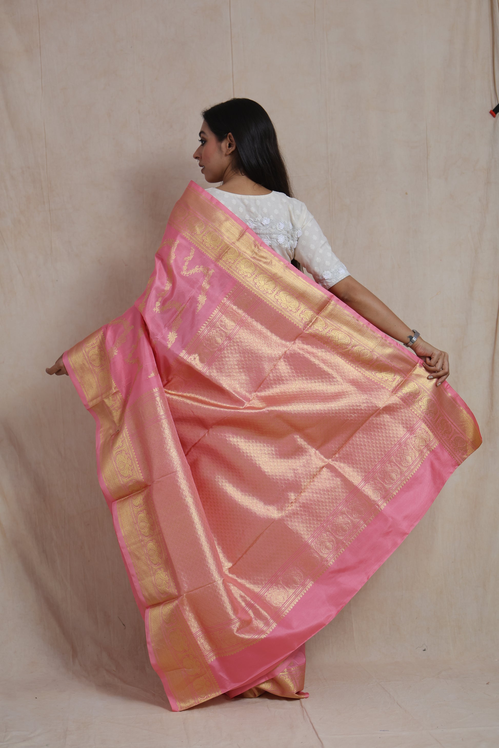Back pallu view of blush pink Kanchipuram silk saree with intricate gold weaving