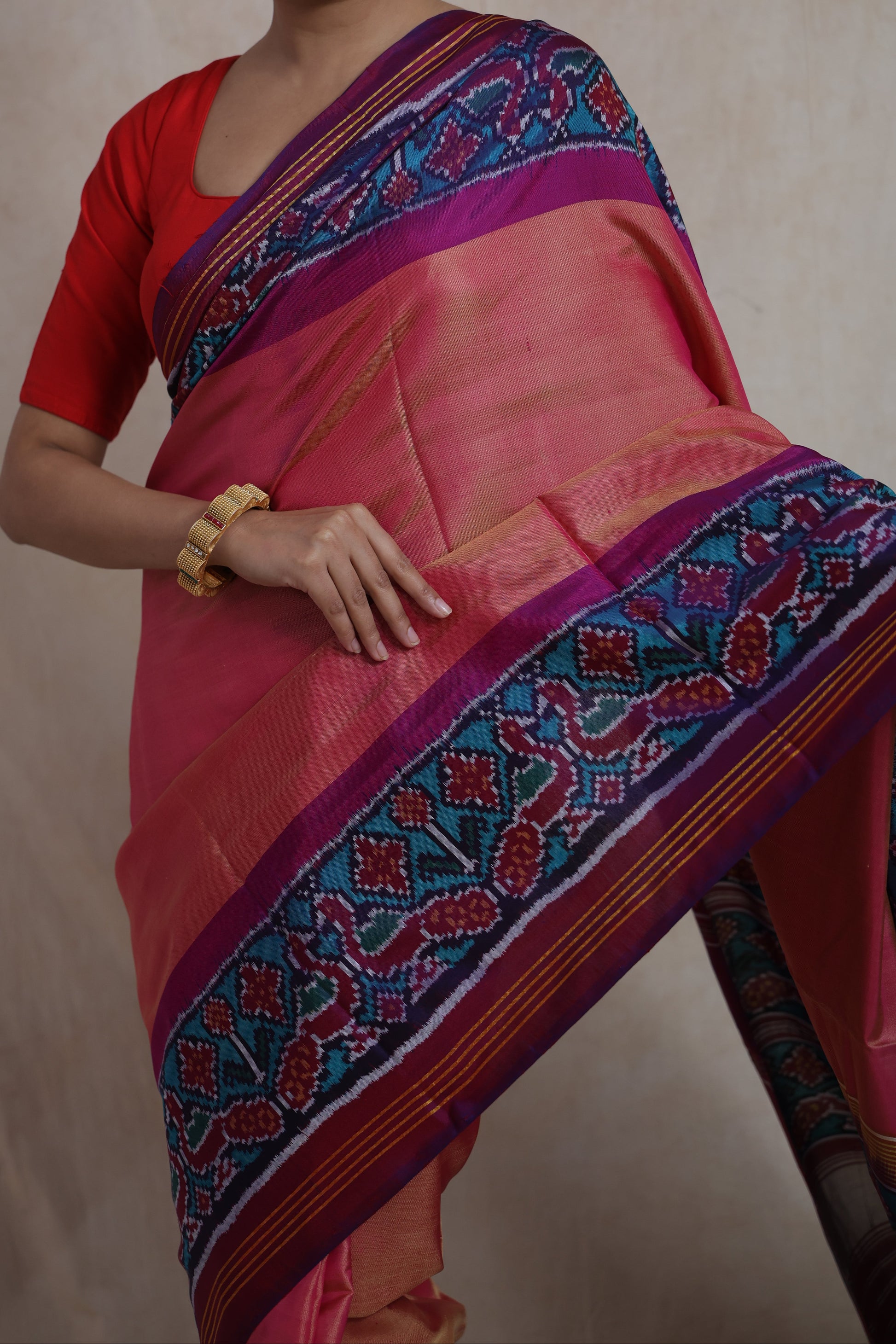 Detailed view of Patola silk saree border featuring traditional ikat motifs in blue, magenta, and red